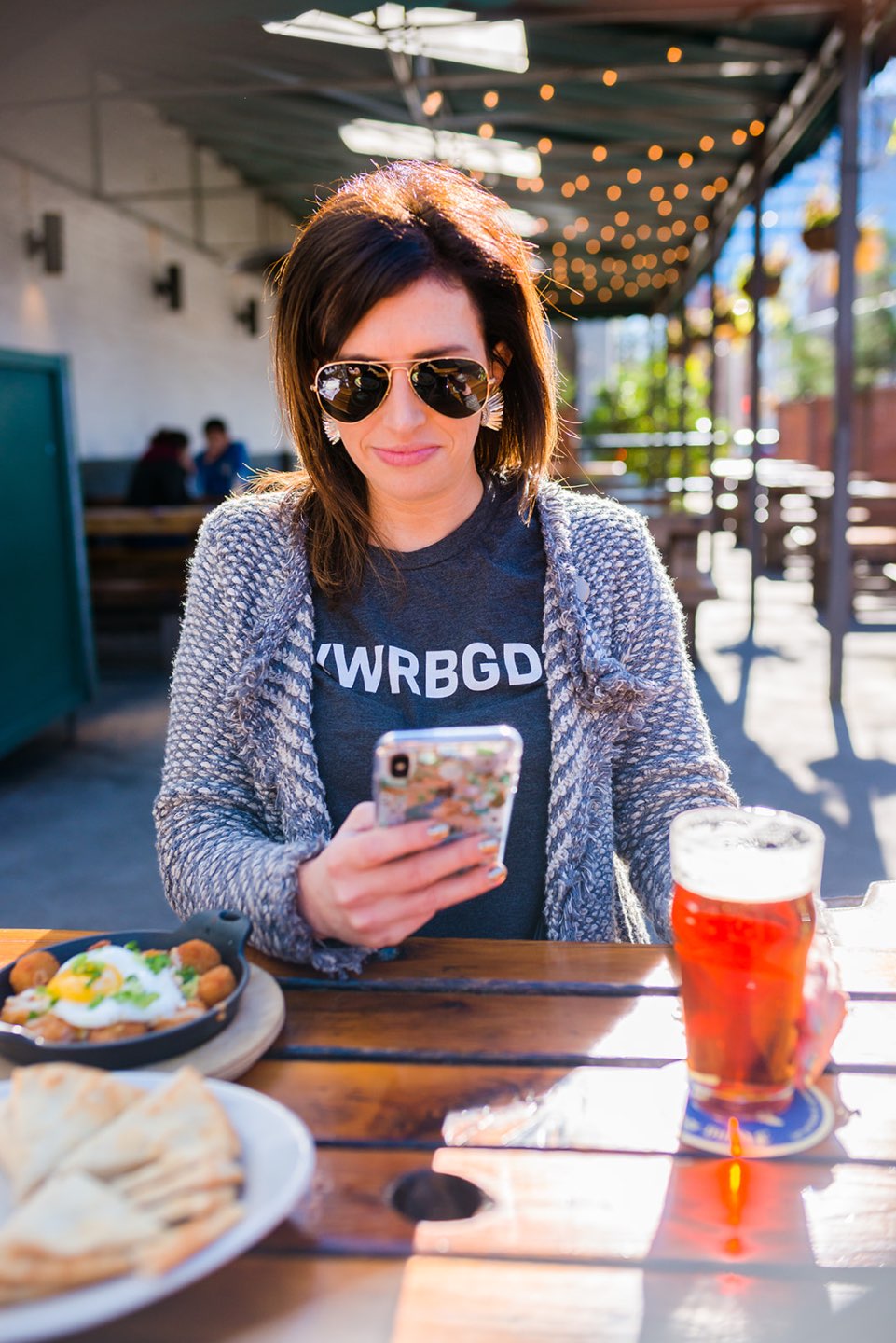 The Best Twitter Accounts to Follow to Stay Informed featured by top US lifestyle blog, I'm Fixin' To: image of a woman scrolling on her cellphone looking at her Twitter feed