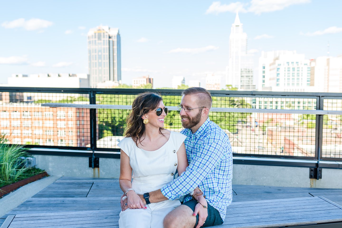 Celebrating 5 Years of Marriage: Lessons Learned - I'm Fixin' To - @mbg0112 | Celebrating 5 Years of Marriage: Lessons Learned - I'm Fixin' To - @mbg0112 | Celebrating 5 Years of Marriage: Lessons Learned by popular North Caroline Life and Style blog, I'm Fixin' To: image of husband and wife sitting next to each other outside. Woman is wearing a Gal Meets Glam jumpsuit, Nordstrom Ebba Sandal by ONO, Ray-Ban Original Aviator Polarized Sunglasses, and Hunter Blake Earrings.