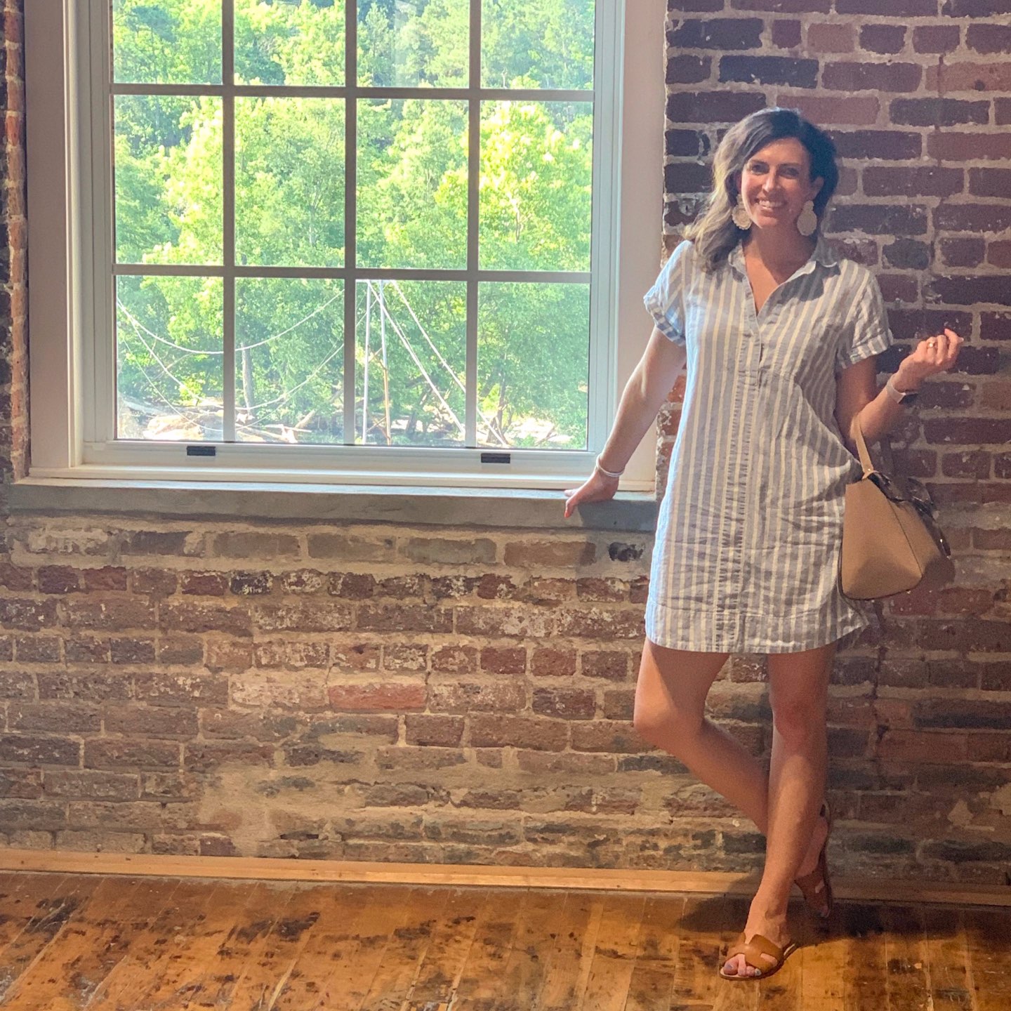 Welcome July + June Instagram Roundup - I'm Fixin' To - @mbg0112 | Welcome July + June Instagram Fashion Roundup by popular North Carolina life and style blog, I'm Fixin' To: image of woman standing inside next to a window wearing a J. Crew Factory blue and white stripe dress, STEVEN by Steve Madden Women's Greece Sandals, BEST LADY Statement Drop Earrings for Women, and holding a Actlure Women's Leather Belt Bag Cross Body Hangbag Purse