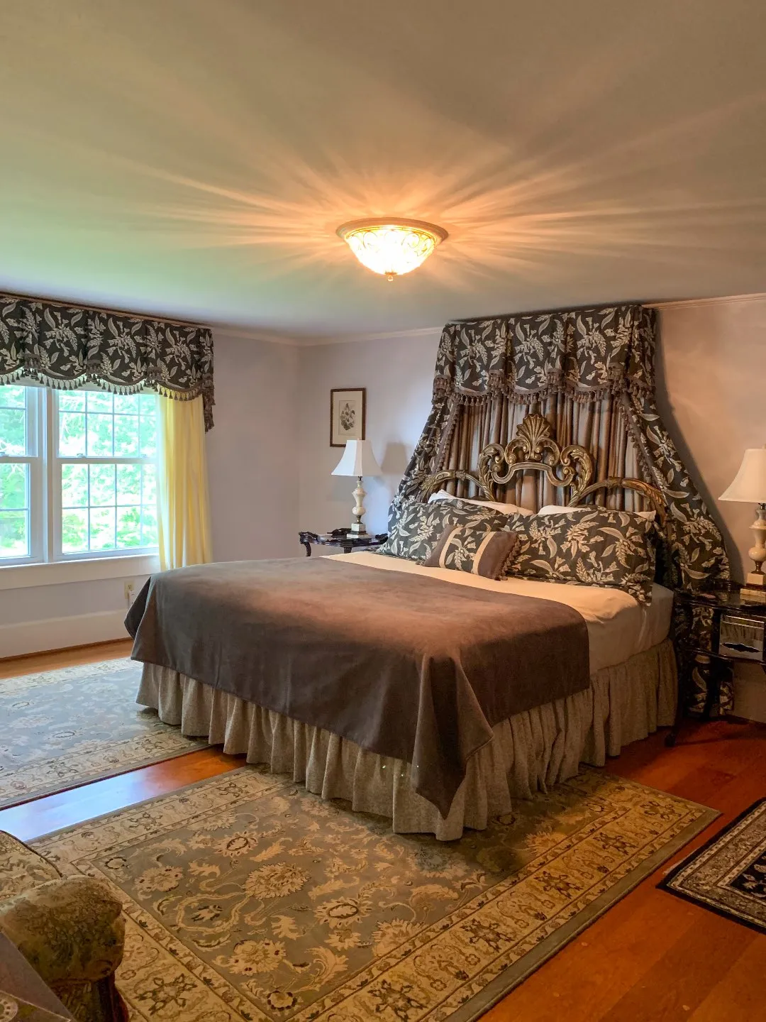 North Carolina Favorite: Between Water and Main Bed & Breakfast in Belhaven - I'm Fixin' To - @mbg0112 | North Carolina Favorite: Between Water and Main Bed & Breakfast in Belhaven by popular North Carolina Blogger, I'm Fixin' To: image of a king size bed with brown and cream bedding and a ornate gold headboard in a bedroom at Between Water and Main Bed and Breakfast.