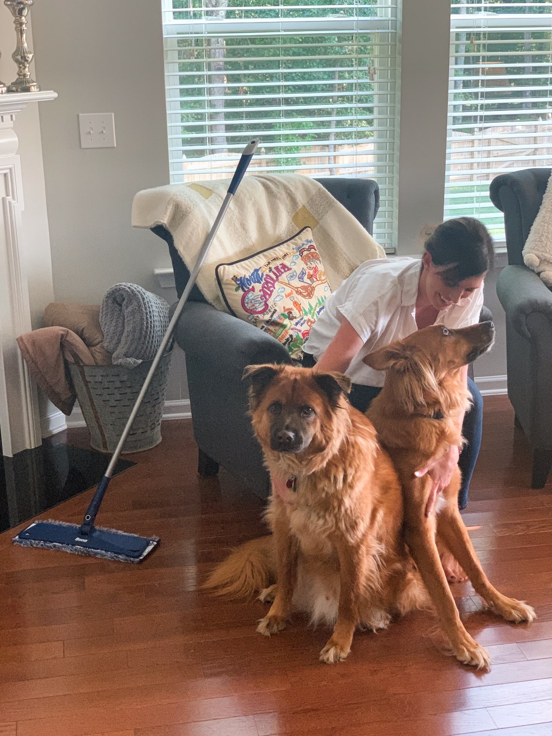 Keeping Our Floors Clean with Bona Essentials - I'm Fixin' To - @mbg0112 | Keeping Our Floors Clean with Bona Essentials by popular lifestyle blog, I'm Fixin' To: image of a woman sitting in an arm chair with her two large dogs at her feet and a Bona Essentials mop propped up against the chair.