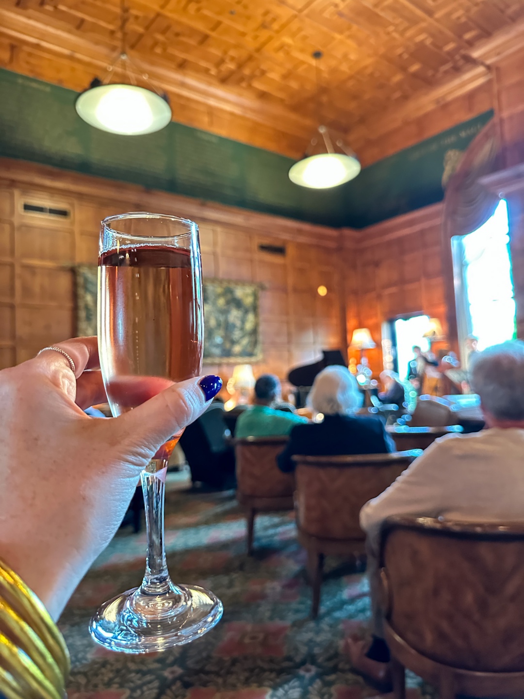 Meghan Grant holding a glass of Champaign in a restaurant