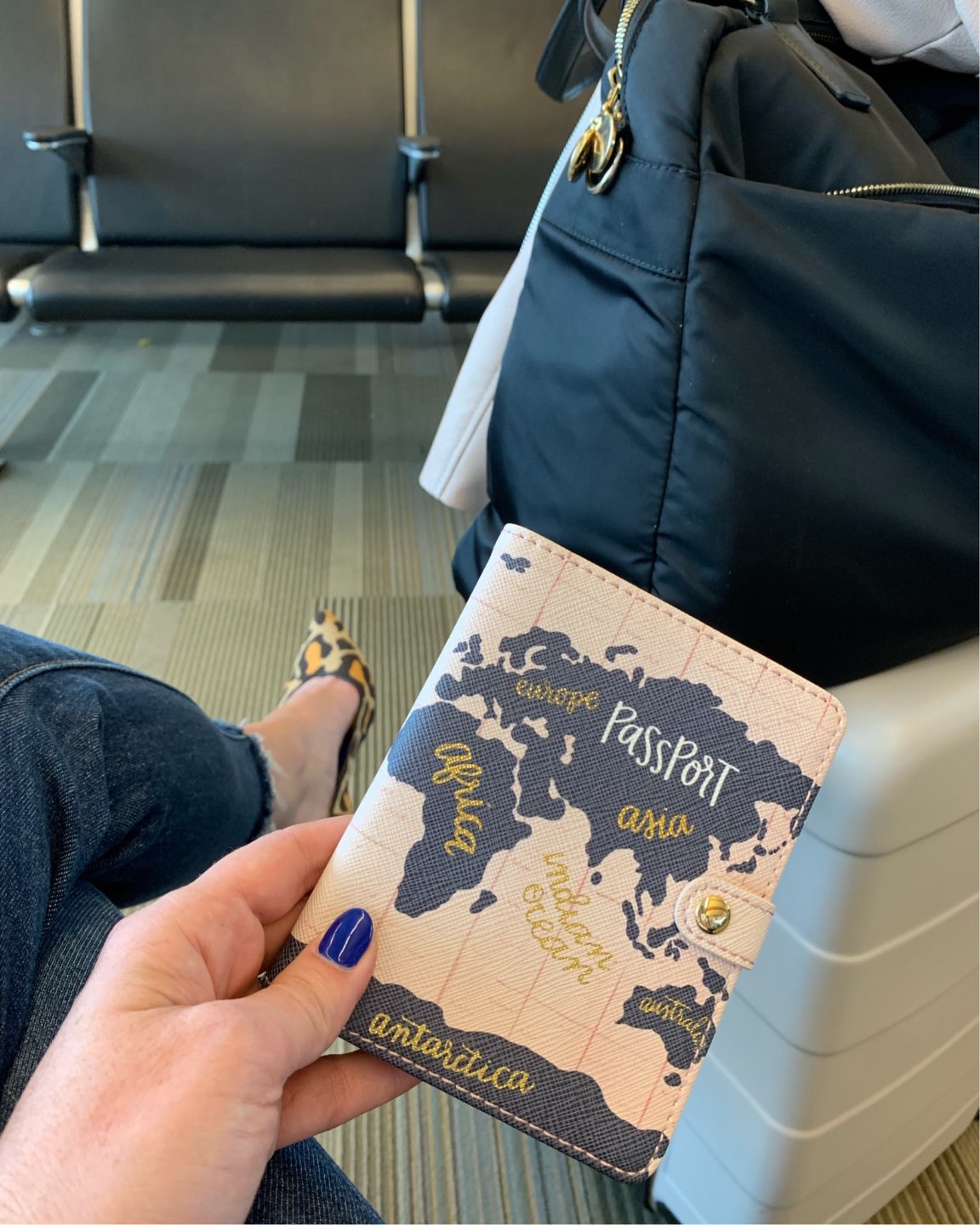 Welcome August + July 2019 Instagram Roundup - I'm Fixin' To - @mbg0112 | Welcome August + July 2019 Instagram Roundup by popular North Carolina life and style blog, I'm Fixin' To: image of a woman holding a passport and wearing leopard Rothy's, Levi's Women's Wedgie Skinny Jeans, OPI Nail Lacquer-Blues, and sitting next to her Hardside Carry On Spinner Suitcase 20" Tan.