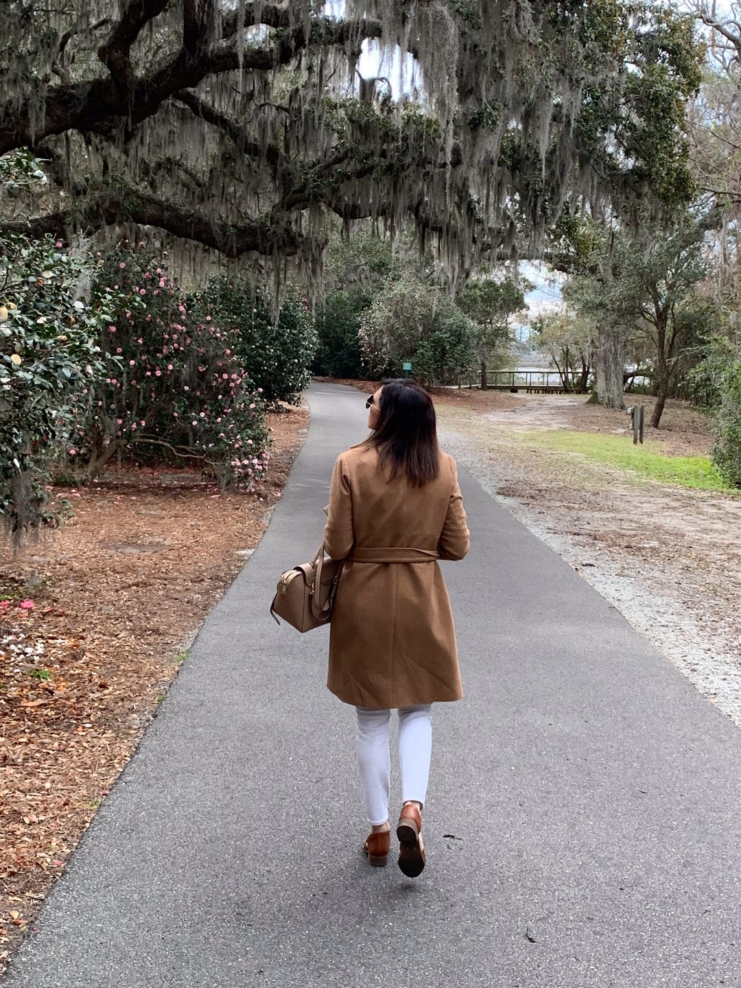 One Year Since Hurricane Florence in North Carolina and How to Help Ocracoke by popular North Carolina blog, I'm Fixin' To: image of a woman walking under and oak tree with Spanish Moss growing on it.
