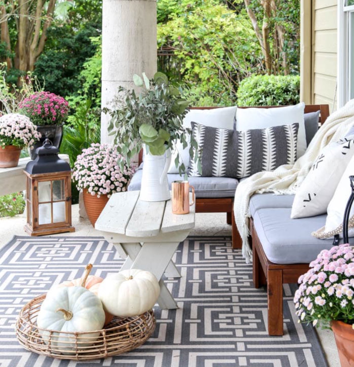 Inspiration Board: Fall Front Porch Ideas by popular North Carolina life and style blog, I'm Fixin' To: image of a front porch decorated with potted purple mums and pumpkins.