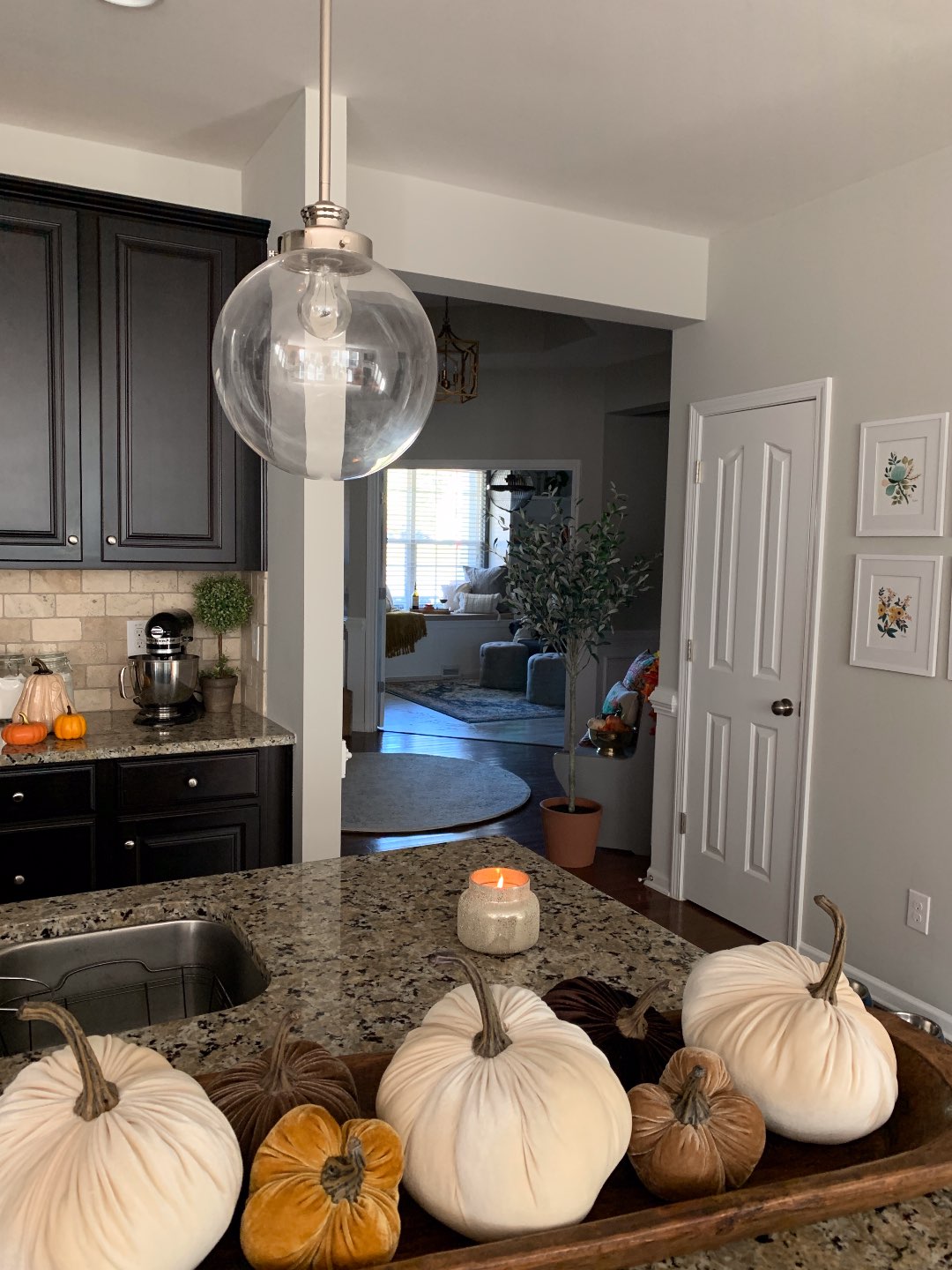 Our Fall Home Decor & Foyer Reveal - I'm Fixin' To - @mbg0112 | Cozy Fall Decor Ideas for your Home & Foyer by popular North Carolina life and style blog, I'm Fixin' To: image of a kitchen counter decorated with a Rancho Adobe Extra Long Rustic Wooden Dough Bowl, Shore Crafty Velvet Pumpkins, and Anthropologie ANTHROPOLOGIE Capri Blue Jar Candle, Main, color, SPICED CIDER DETAILS & CARE 5"H x 4"D 19 oz. 85-hour approximate burn time Soy wax Made in the USA Item #5893885 Free Shipping & Returns See more Capri Blue Jar Candle.