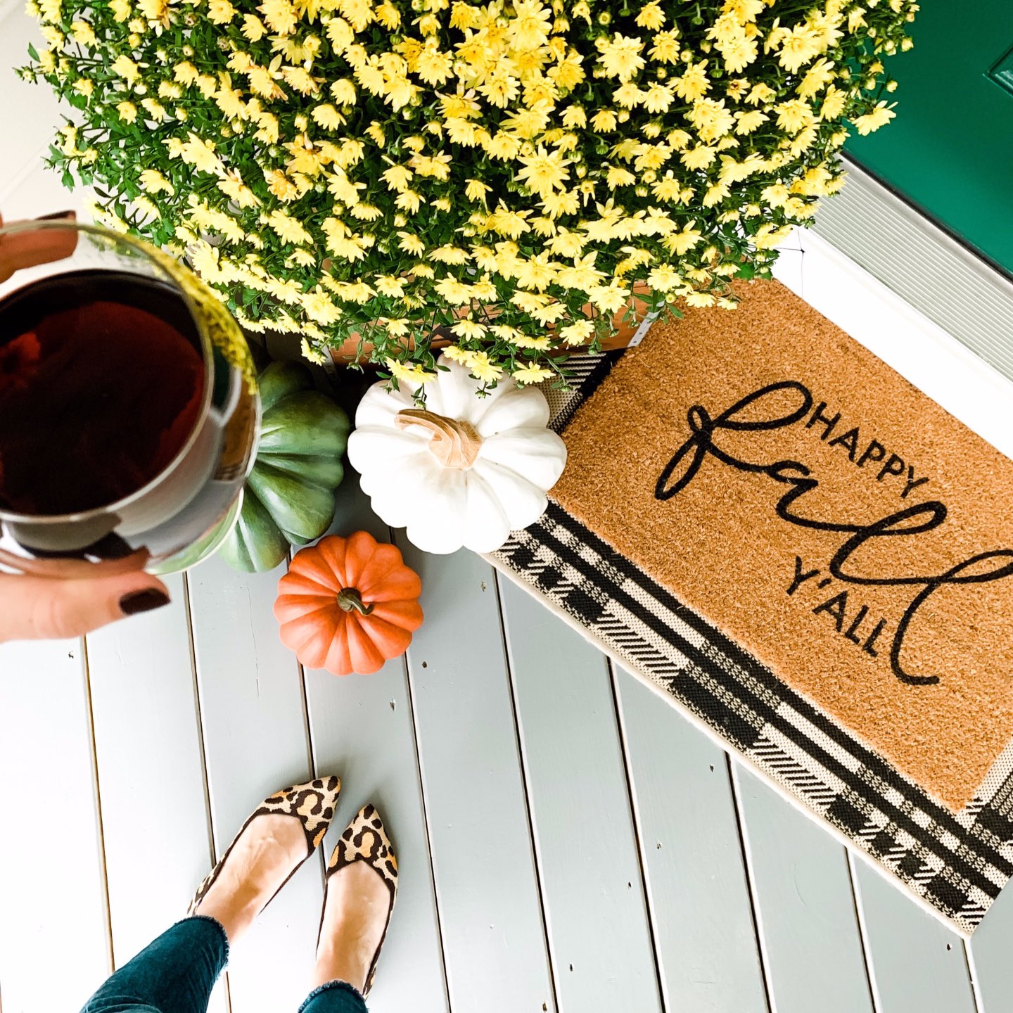 Our Inviting and Cozy Fall Front Porch Decor Ideas - I'm Fixin' To - @mbg0112 | Our Inviting and Cozy Fall Front Porch Decor Ideas by popular North Carolina lifestyle blog, I'm Fixin' To: image of a yellow mums, faux pumpkins, and buffalo plaid door mat.