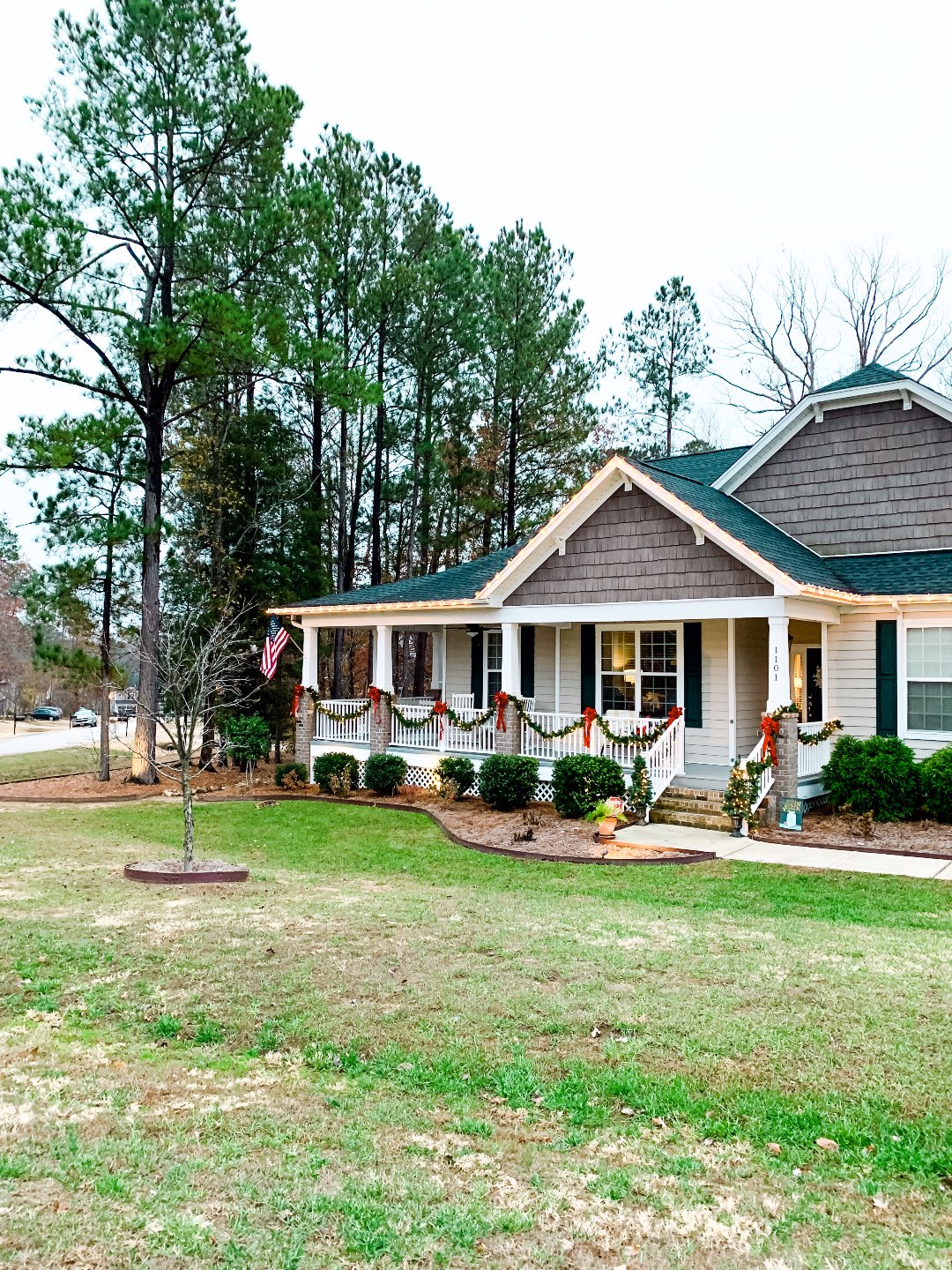 Holiday Home Decor Tour - I'm Fixin' To - @mbg0112 | Holiday Home Decor Tour by popular North Carolina life and style blog, I'm Fixin' To: image of a home exterior decorated with Pre-Lit Garland, Potted Pre-Lit Trees, Pottery Barn Door Mat (old, love this option), Plaid Mat, 3 Foot Pre-Lit Tree Buffalo Plaid Pillow Covers, and White Berry Wreath.