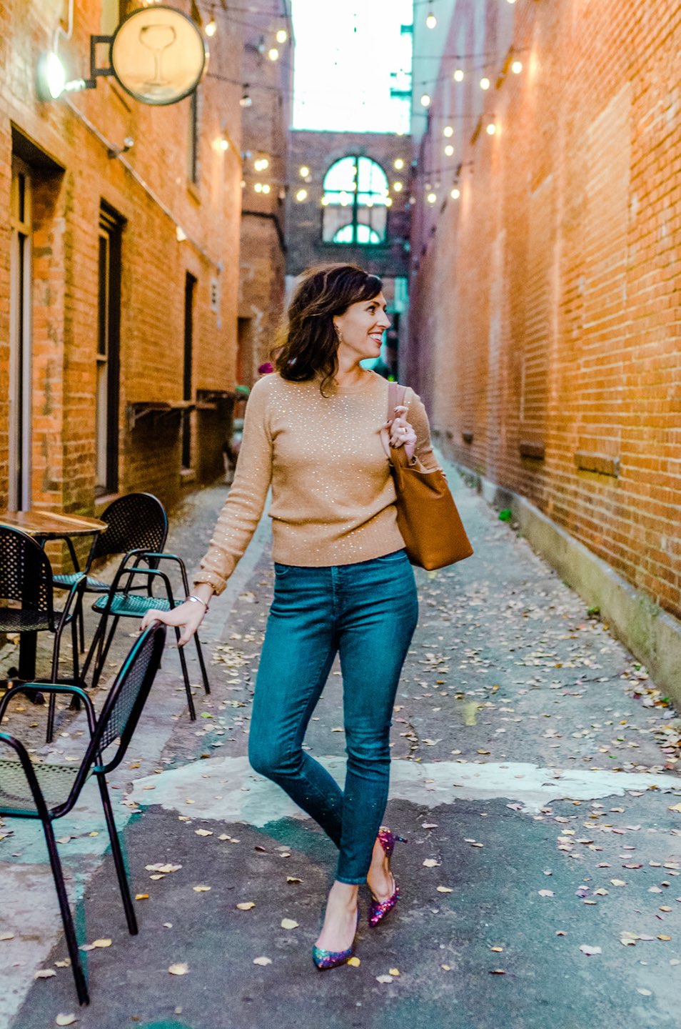 Holiday Style and Outfit Inspiration - I'm Fixin' To - @mbg0112 | Holiday Style and Outfit Inspiration by popular North Carolina fashion blog, I'm Fixin' To: image of a woman outside wearing a J. Crew Gemstone sweater in supersoft yarn, J. Crew 8" toothpick jean in Vista wash, J. Crew Colette d'Orsay pumps in holographic glitter, Cuyana Small Structured Leather Tote, Nordstrom David Yurman Cable Classic Buckle Bracelet with 18K Gold, Nordstrom David Yurman Cable Classics Bracelet with 14K Gold, Nordstrom Mignonne Gavigan Earrings, and Sephora Bite Beauty lipstick.