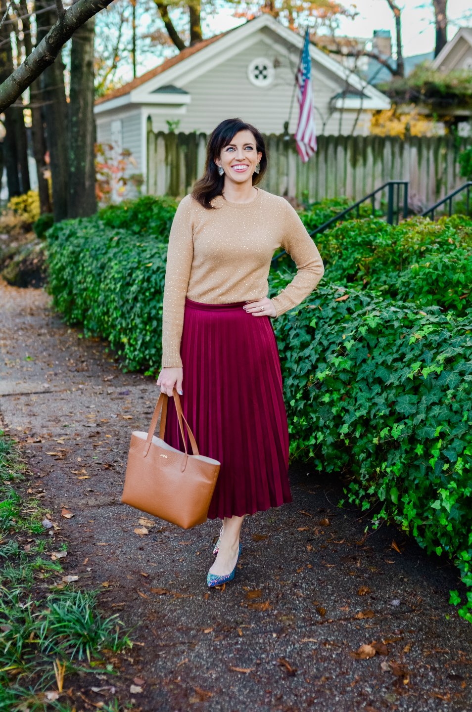 Holiday Style and Outfit Inspiration - I'm Fixin' To - @mbg0112 | Holiday Style and Outfit Inspiration by popular North Carolina fashion blog, I'm Fixin' To: image of a woman outside wearing a J. Crew Gemstone sweater in supersoft yarn, J. Crew Pleated midi skirt, J. Crew Colette d'Orsay pumps in holographic glitter, Cuyana Small Structured Leather Tote, Nordstrom David Yurman Cable Classic Buckle Bracelet with 18K Gold, Nordstrom David Yurman Cable Classics Bracelet with 14K Gold, Nordstrom Mignonne Gavigan Earrings, and Sephora Bite Beauty lipstick.