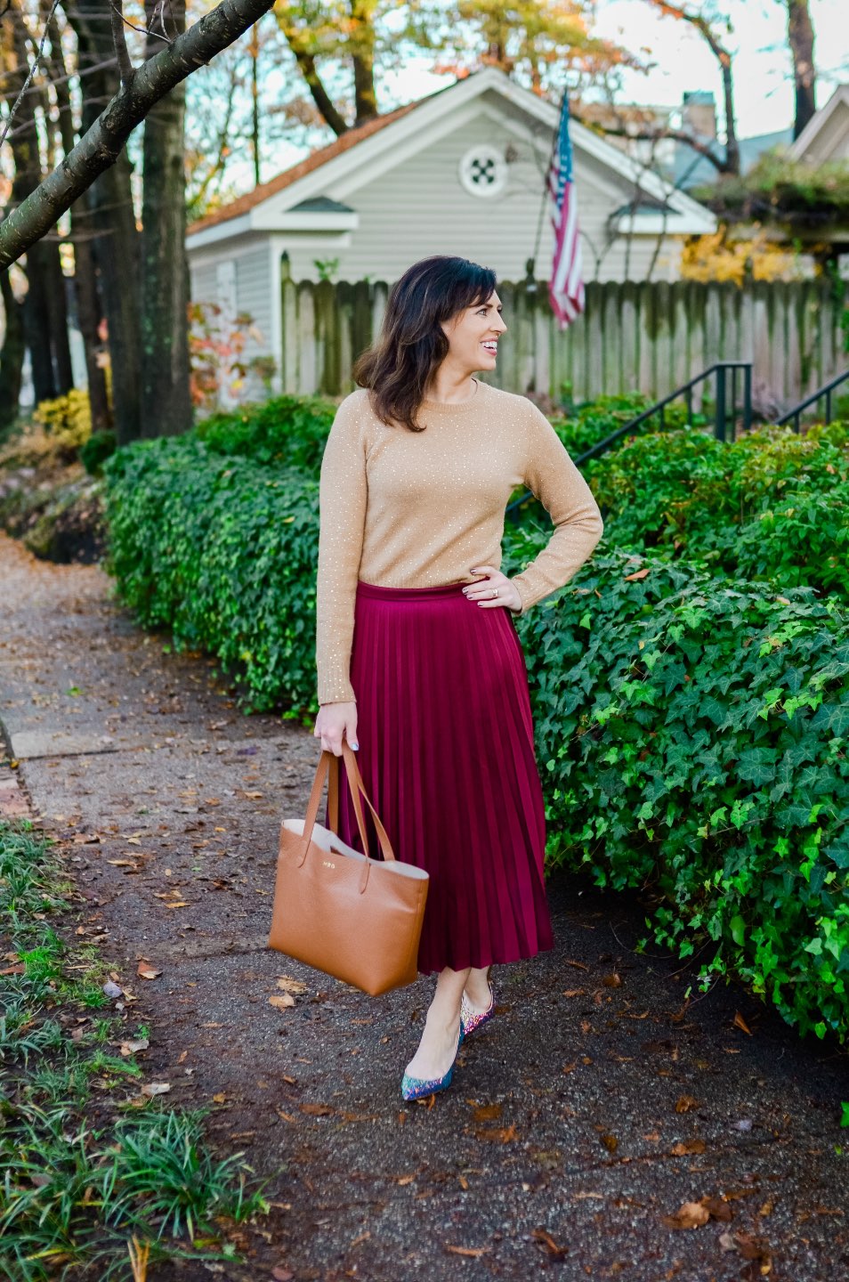 Holiday Style and Outfit Inspiration - I'm Fixin' To - @mbg0112 | Holiday Style and Outfit Inspiration by popular North Carolina fashion blog, I'm Fixin' To: image of a woman outside wearing a J. Crew Gemstone sweater in supersoft yarn, J. Crew Pleated midi skirt, J. Crew Colette d'Orsay pumps in holographic glitter, Cuyana Small Structured Leather Tote, Nordstrom David Yurman Cable Classic Buckle Bracelet with 18K Gold, Nordstrom David Yurman Cable Classics Bracelet with 14K Gold, Nordstrom Mignonne Gavigan Earrings, and Sephora Bite Beauty lipstick.