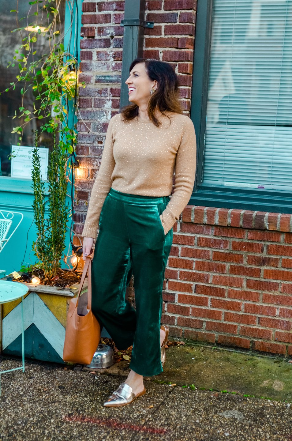 Holiday Style and Outfit Inspiration - I'm Fixin' To - @mbg0112 | Holiday Style and Outfit Inspiration by popular North Carolina fashion blog, I'm Fixin' To: image of a woman outside wearing a J. Crew Gemstone sweater in supersoft yarn, J. Crew Pull-on Peyton pant in velvet, metallic mules, Cuyana Small Structured Leather Tote, Nordstrom David Yurman Cable Classic Buckle Bracelet with 18K Gold, Nordstrom David Yurman Cable Classics Bracelet with 14K Gold, Nordstrom Mignonne Gavigan Earrings, and Sephora Bite Beauty lipstick.