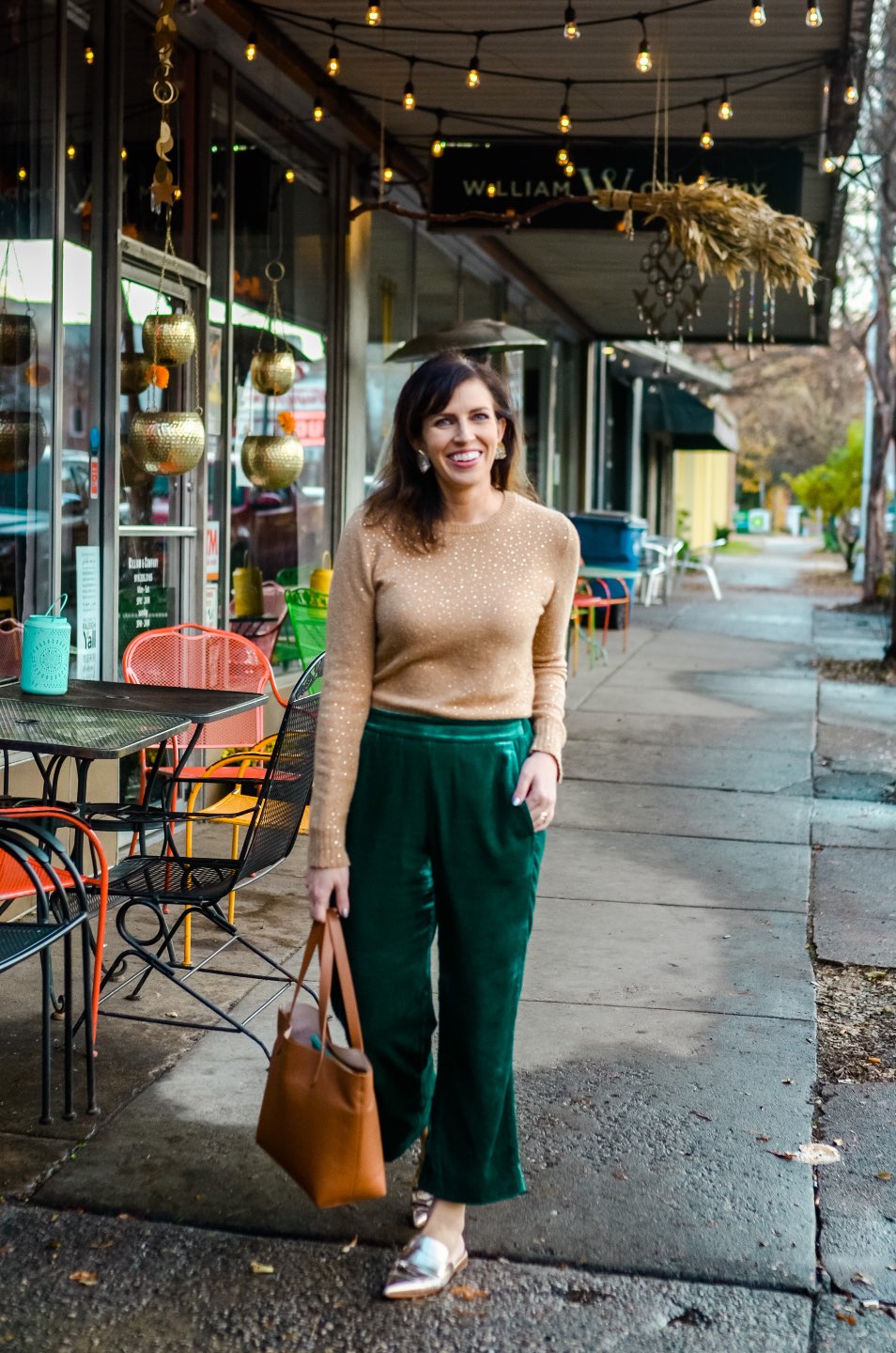 Holiday Style and Outfit Inspiration - I'm Fixin' To - @mbg0112 | Holiday Style and Outfit Inspiration by popular North Carolina fashion blog, I'm Fixin' To: image of a woman outside wearing a J. Crew Gemstone sweater in supersoft yarn, J. Crew Pull-on Peyton pant in velvet, metallic mules, Cuyana Small Structured Leather Tote, Nordstrom David Yurman Cable Classic Buckle Bracelet with 18K Gold, Nordstrom David Yurman Cable Classics Bracelet with 14K Gold, Nordstrom Mignonne Gavigan Earrings, and Sephora Bite Beauty lipstick.