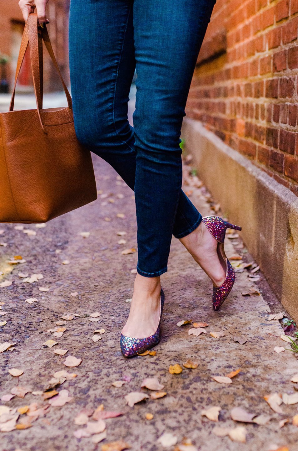 Holiday Style and Outfit Inspiration - I'm Fixin' To - @mbg0112 Holiday Style and Outfit Inspiration by popular North Carolina fashion blog, I'm Fixin' To: image of a woman outside wearing a J. Crew Gemstone sweater in supersoft yarn, J. Crew 8" toothpick jean in Vista wash, J. Crew Colette d'Orsay pumps in holographic glitter, Cuyana Small Structured Leather Tote, Nordstrom David Yurman Cable Classic Buckle Bracelet with 18K Gold, Nordstrom David Yurman Cable Classics Bracelet with 14K Gold, Nordstrom Mignonne Gavigan Earrings, and Sephora Bite Beauty lipstick.