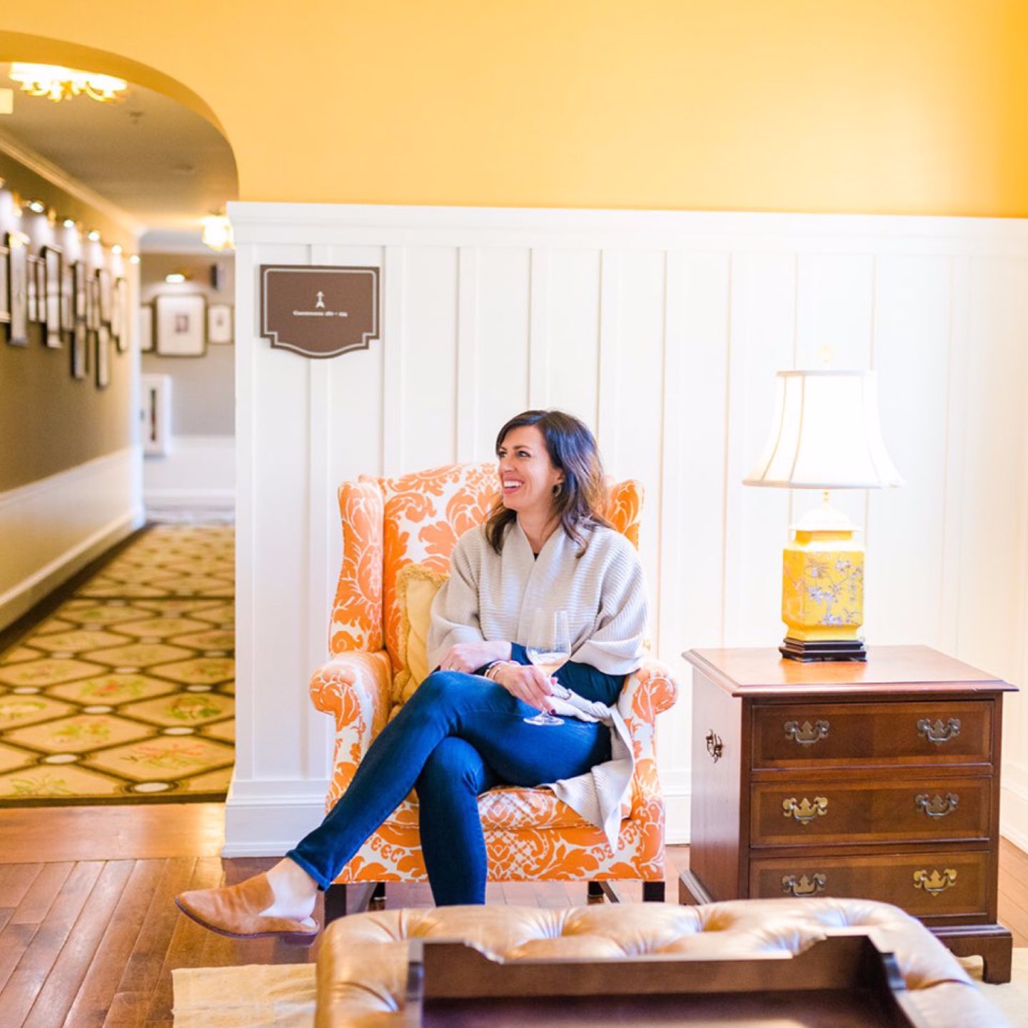 How to Set Healthy Boundaries with Friends: 8 Essential Tips - I'm Fixin' To - @mbg0112 | How to Set Healthy Boundaries with Friends: 8 Essential Tips by popular NC life and style blog, I'm Fixin' To: image of a woman drinking a glass of wine and sitting in a orange arm chair.
