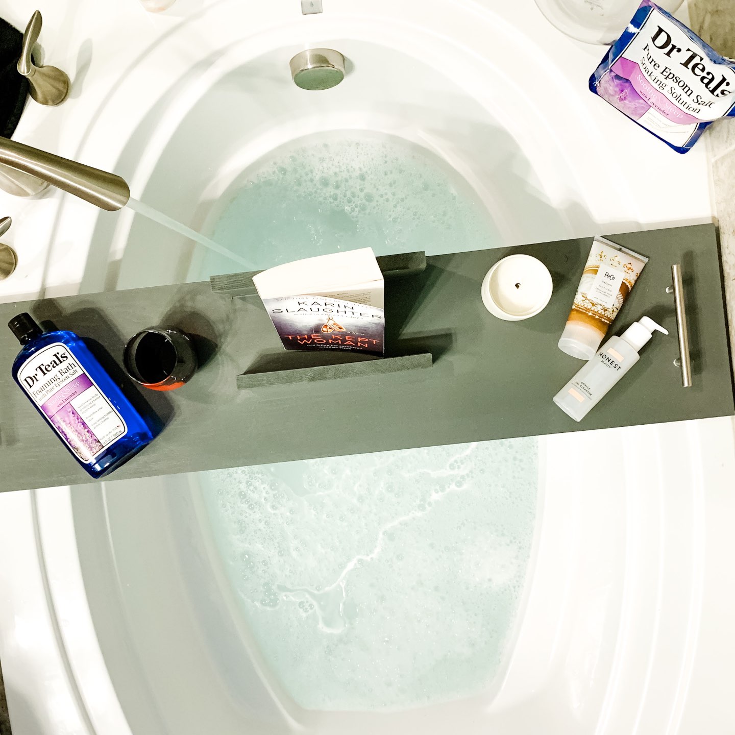 How I'm Learning to Do Nothing - I'm Fixin' To - @mbg0112 |  Learning to do Nothing by popular N.C. lifestyle blog, I'm Fixin' To: image of a bath tray with a book, candle, and Dr. Teal's Foaming Bath with pure epsom salt. 