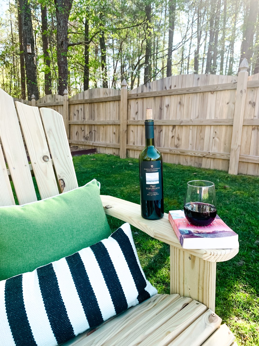 Top 10 Best Wines by popular N.C. lifestyle blog, I'm Fixin' To: image of a bottle of Finca Flinchman Malbec on a lounge chair outside.