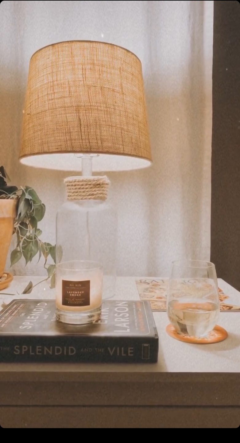 Home Fragrances for an Instant Pick-Me-Up during Quarantine (or Anytime!) - I'm Fixin' To - @mbg0112 | Home Fragrances by popular N.C. life and style blog, I'm Fixin' To: image of a night stand with a lamp, glass of water, The Splendid and the Vile book, and a Na Nin Lavender Smoke scented candle.