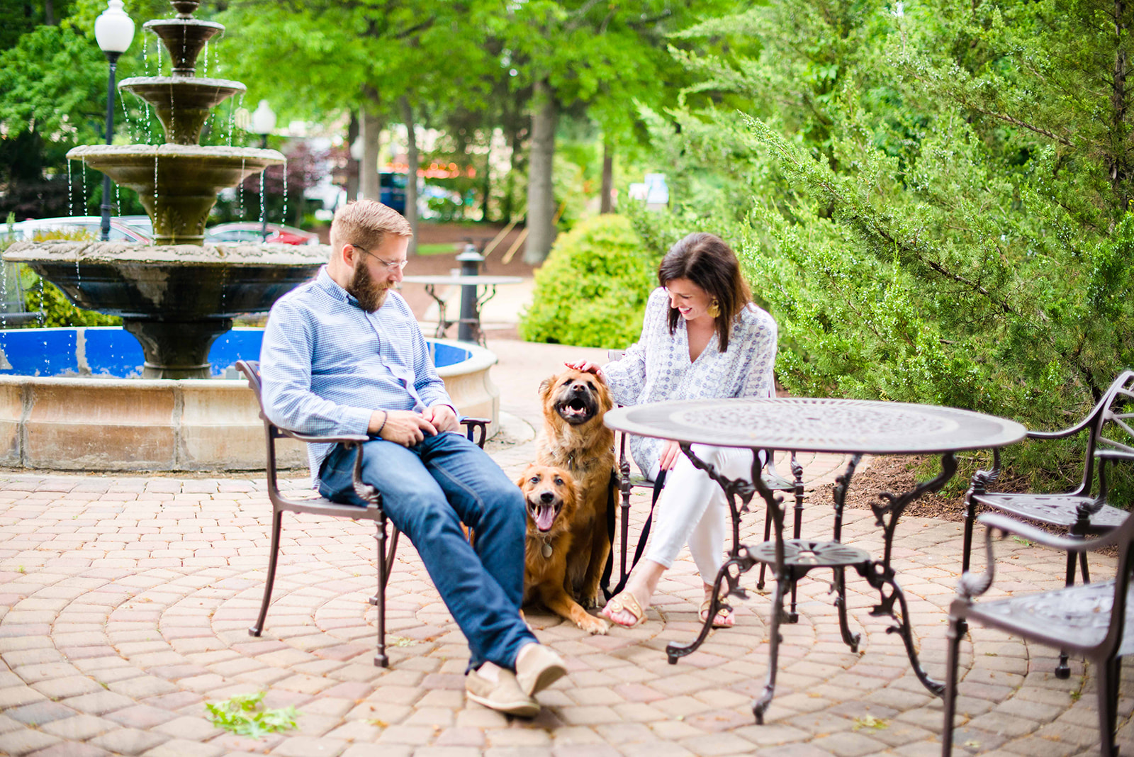 North Carolina Destinations by popular North Carolina blog, I'm Fixin' To: image of a man and woman sitting outside by a fountain with their two dogs. 