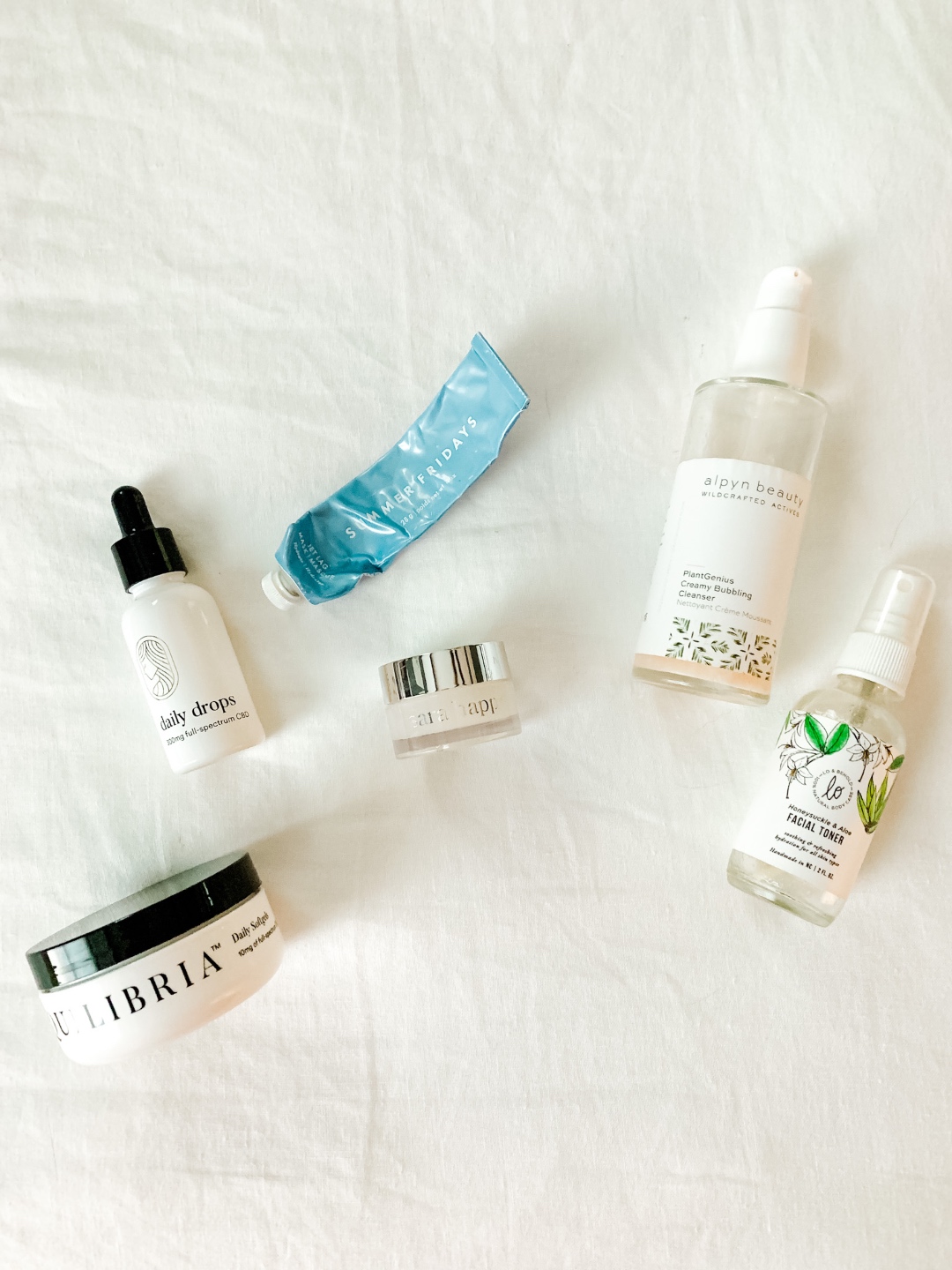 Product Empties by popular North Carolina beauty blog, I'm Fixin' To: image of Equilibria Daily Drops, Lo & Behold Honeysuckle & Aloe Facial Toner, Equilibria Daily Softgels, Alpyn Beauty PlantGenius Creamy Bubbling Cleanser, and Coola Radical Recovery After-Sun Lotion.