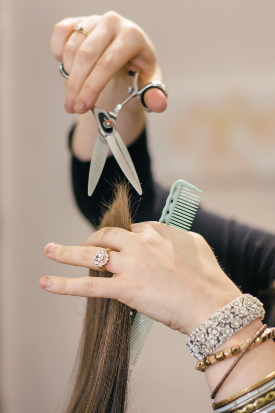 Salon Lofts Falls of Neuse Olive Park by popular N.C. lifestyle blog, I'm Fixin' To: image of a woman cutting another woman's hair and holding a mint green hair comb. 