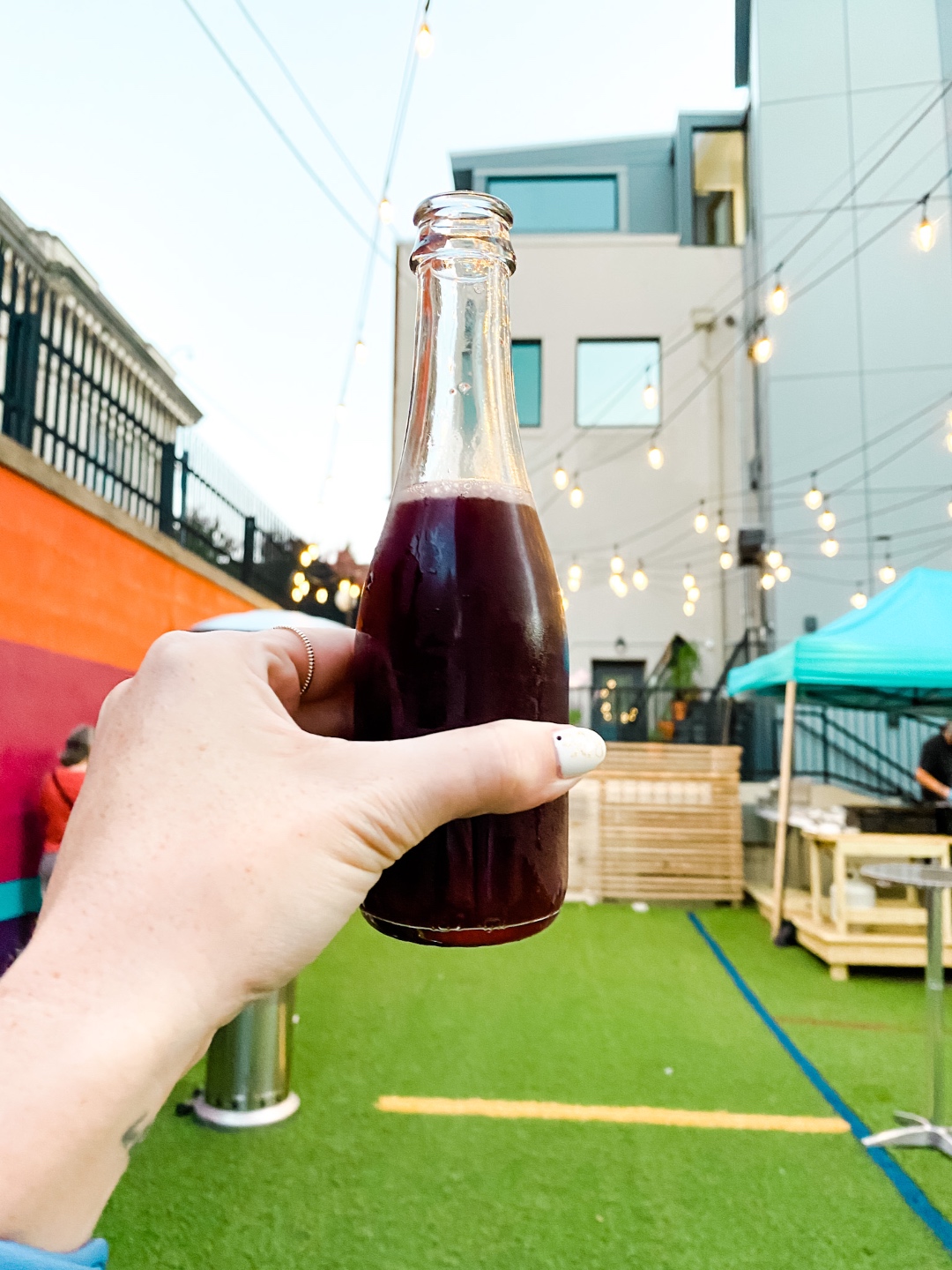 Date Night at the The Streetery in Downtown Durham - I'm Fixin' To - @mbg0112 |The Streetery in Downtown Durham by popular N.C. blog, I'm Fixin' To: image of a woman holding a drink at Queen Burger. 