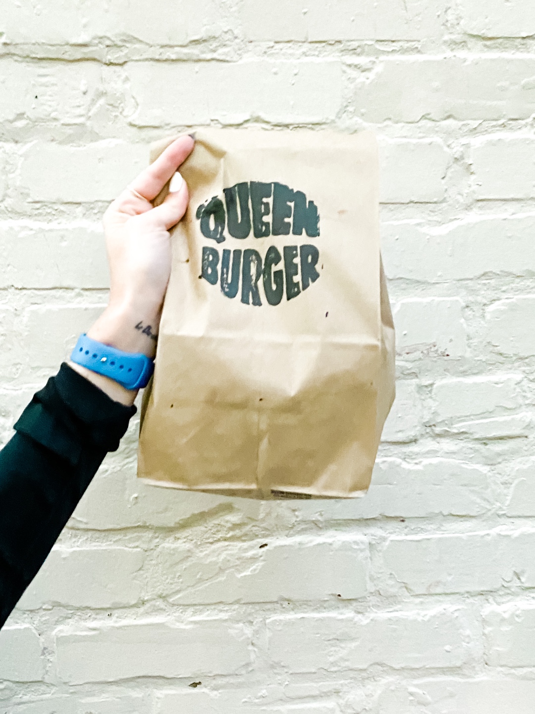 Date Night at the The Streetery in Downtown Durham - I'm Fixin' To - @mbg0112 |The Streetery in Downtown Durham by popular N.C. blog, I'm Fixin' To: image of a woman holding a Queen Burger bag. 