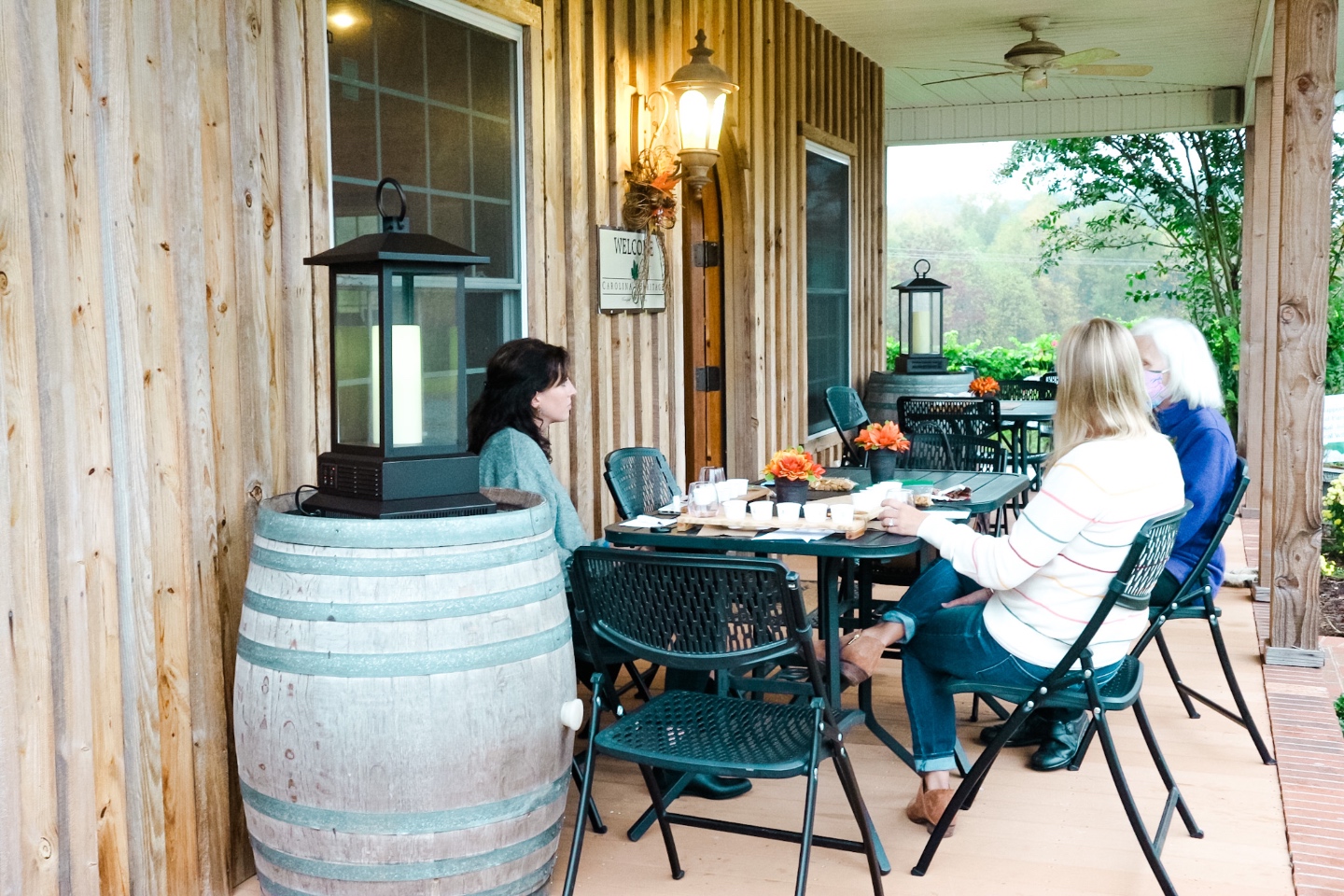 Western NC Wineries: 6 Wineries to Visit During your Next Girls' Weekend - I'm Fixin' To - @mbg0112 |Western NC Wineries by popular NC blog, I'm Fixin' To: image of three women sitting outside at Carolina Heritage vineyard and winery. 