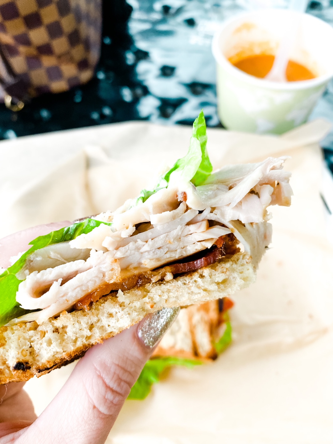 Western NC Wineries: 6 Wineries to Visit During your Next Girls' Weekend - I'm Fixin' To - @mbg0112 |Western NC Wineries by popular NC blog, I'm Fixin' To: image of a woman holding a BLT sandwich at Harvest Grill. 