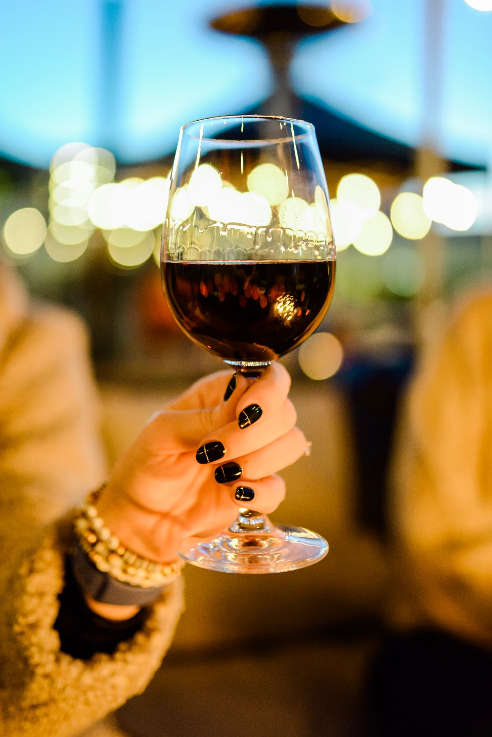 Restaurants with Patios in the Triangle by popular NC lifestyle blog, I'm Fixin' To: image of a woman holding a glass of wine.