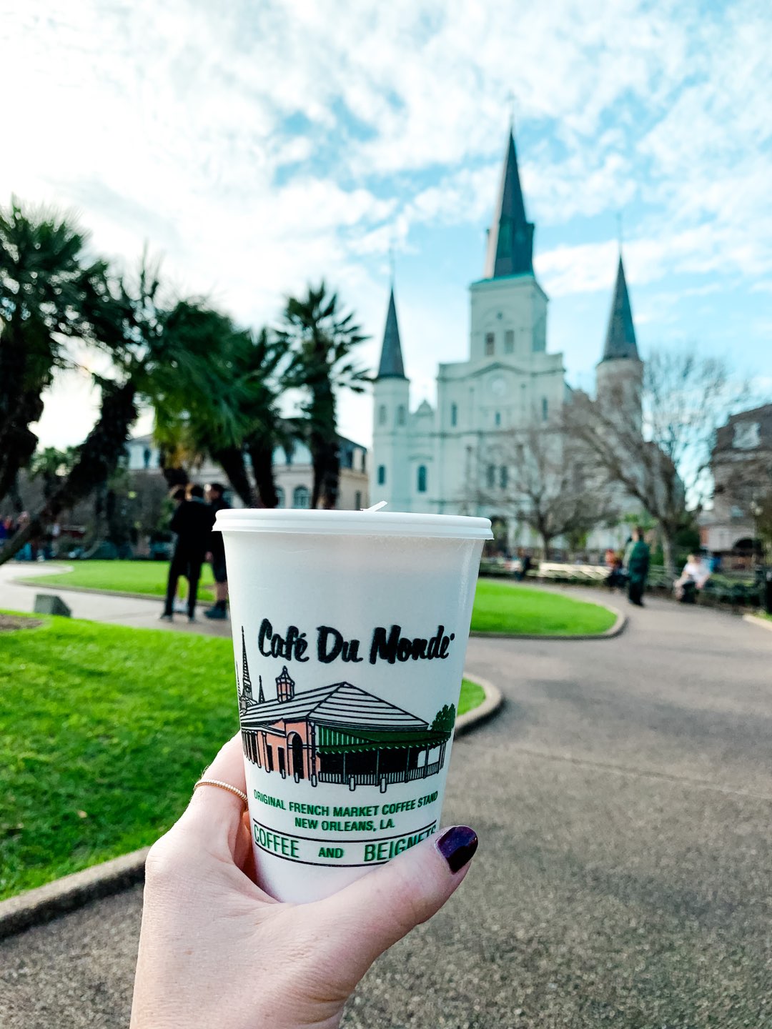 2020, a Year in Review: our Travel Adventures - I'm Fixin' To - @imfixintoblog |Year in Review by popular NC travel blog, I'm Fixin' To: image of a woman holding a Cafe Du Monde cup in New Orleans.