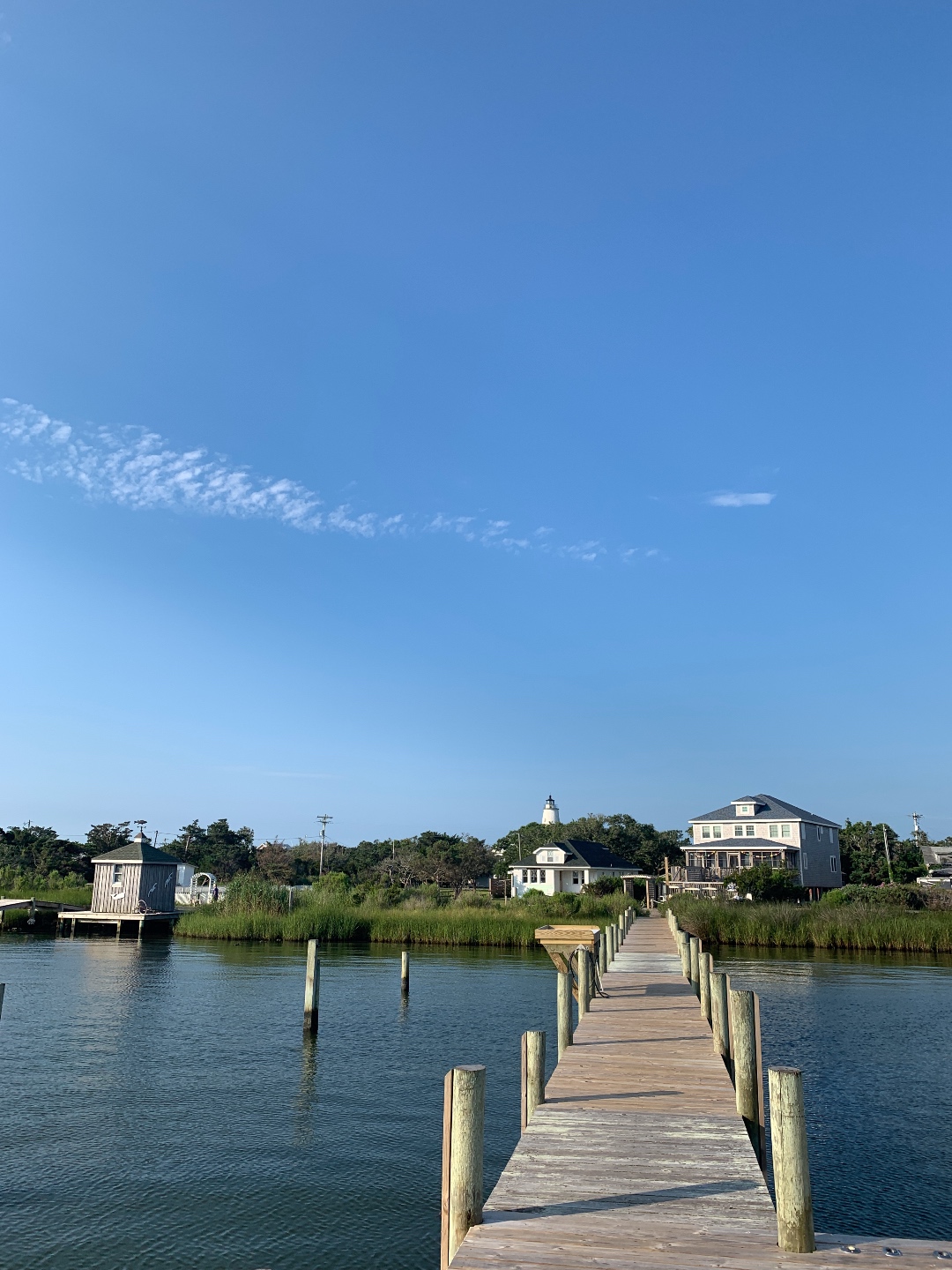 2020, a Year in Review: our Travel Adventures - I'm Fixin' To - @imfixintoblog |Year in Review by popular NC travel blog, I'm Fixin' To: image of a pier leading to some white buildings in Ocracoke.