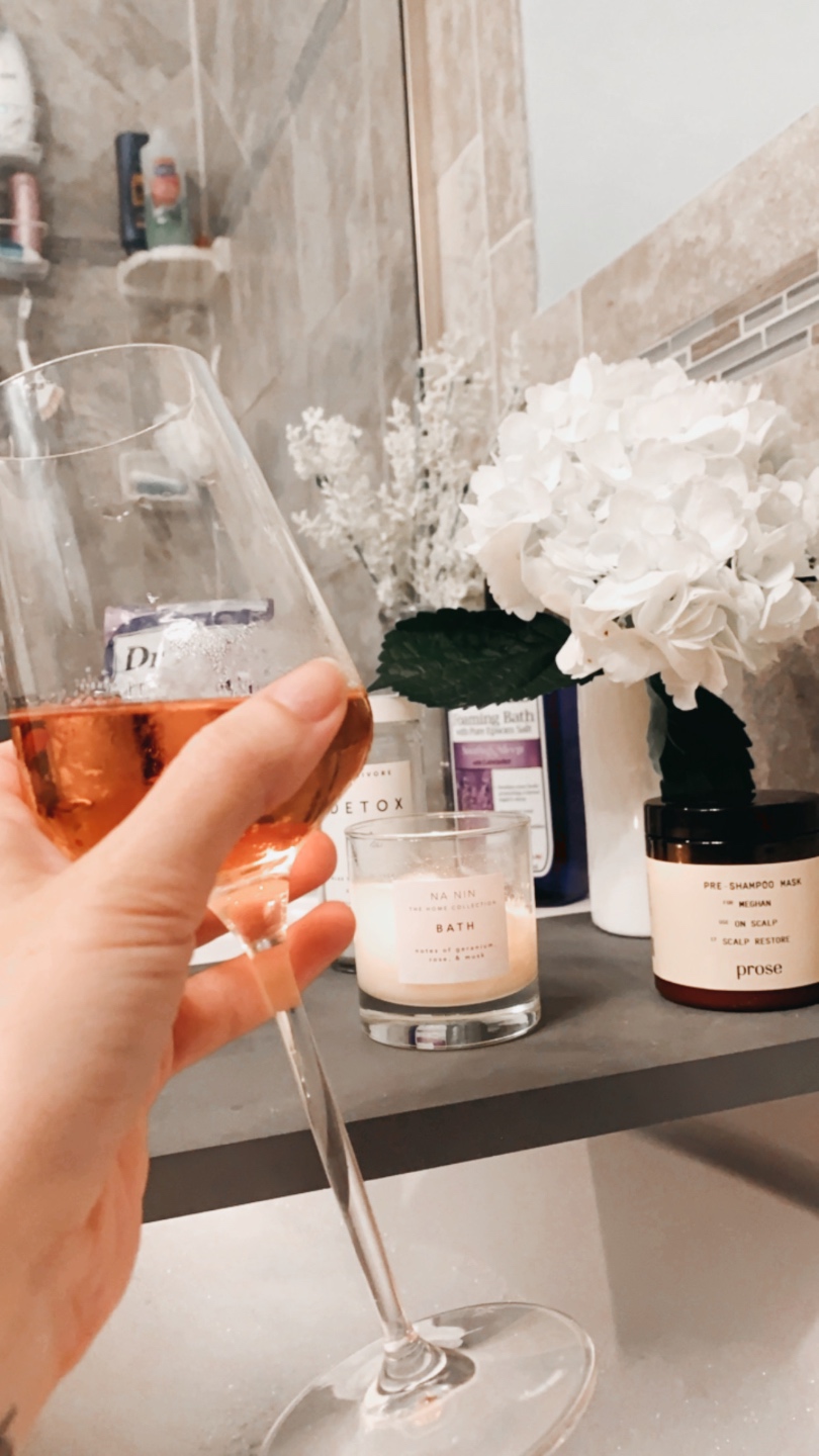 How to Make your Home Cozy: 10 Easy Ways - I'm Fixin' To - @imfixintoblog |How to Make Your Home Cozy by popular NC life and style blog, I'm Fixin' To: image of a woman holding a glass of wine while sitting in the tub. 