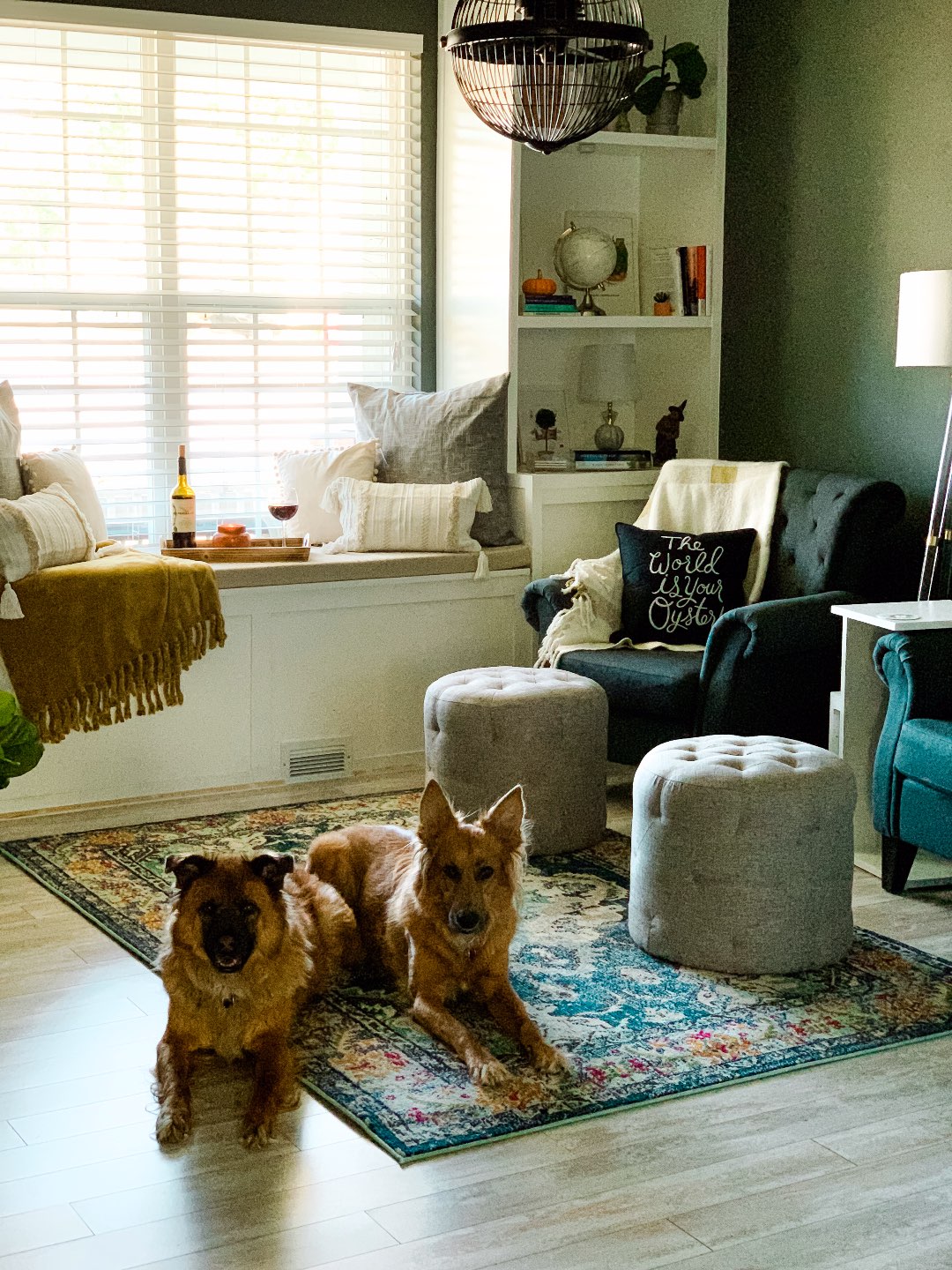How to Make your Home Cozy: 10 Easy Ways - I'm Fixin' To - @imfixintoblog |How to Make Your Home Cozy by popular NC life and style blog, I'm Fixin' To: image of a sitting area with grey tuft armchairs, tan tuft ottomans, floor lamp, and embroidered throw pillows. 