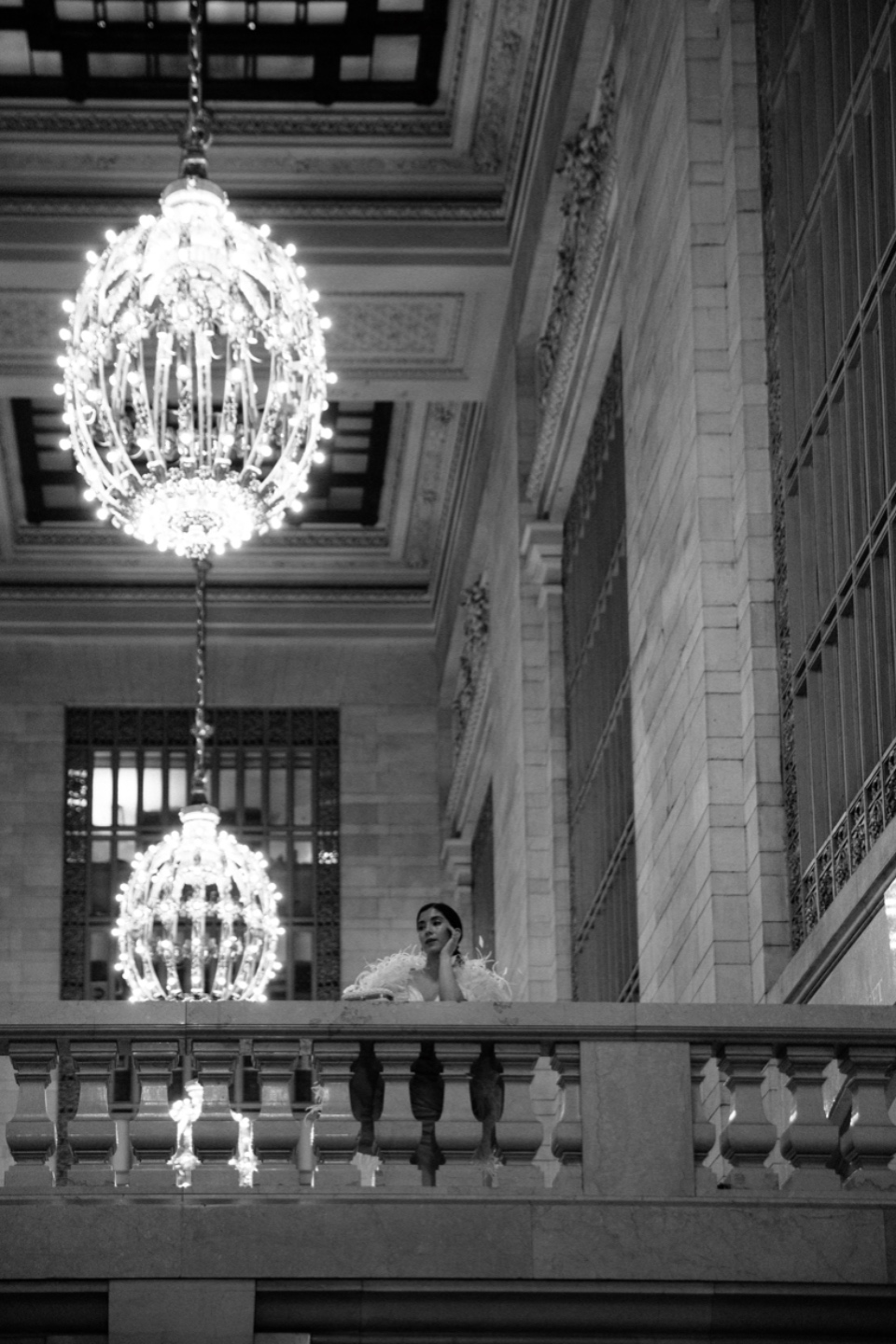 What's Inspiring Me Lately - I'm Fixin' To - @imfixintoblog |What Inspires Me by popular NC lifestyle blog, I'm Fixin' To: black and white image of a woman leaning over a marble balcony while standing under large crystal chandeliers and wearing a feather embellished dress.