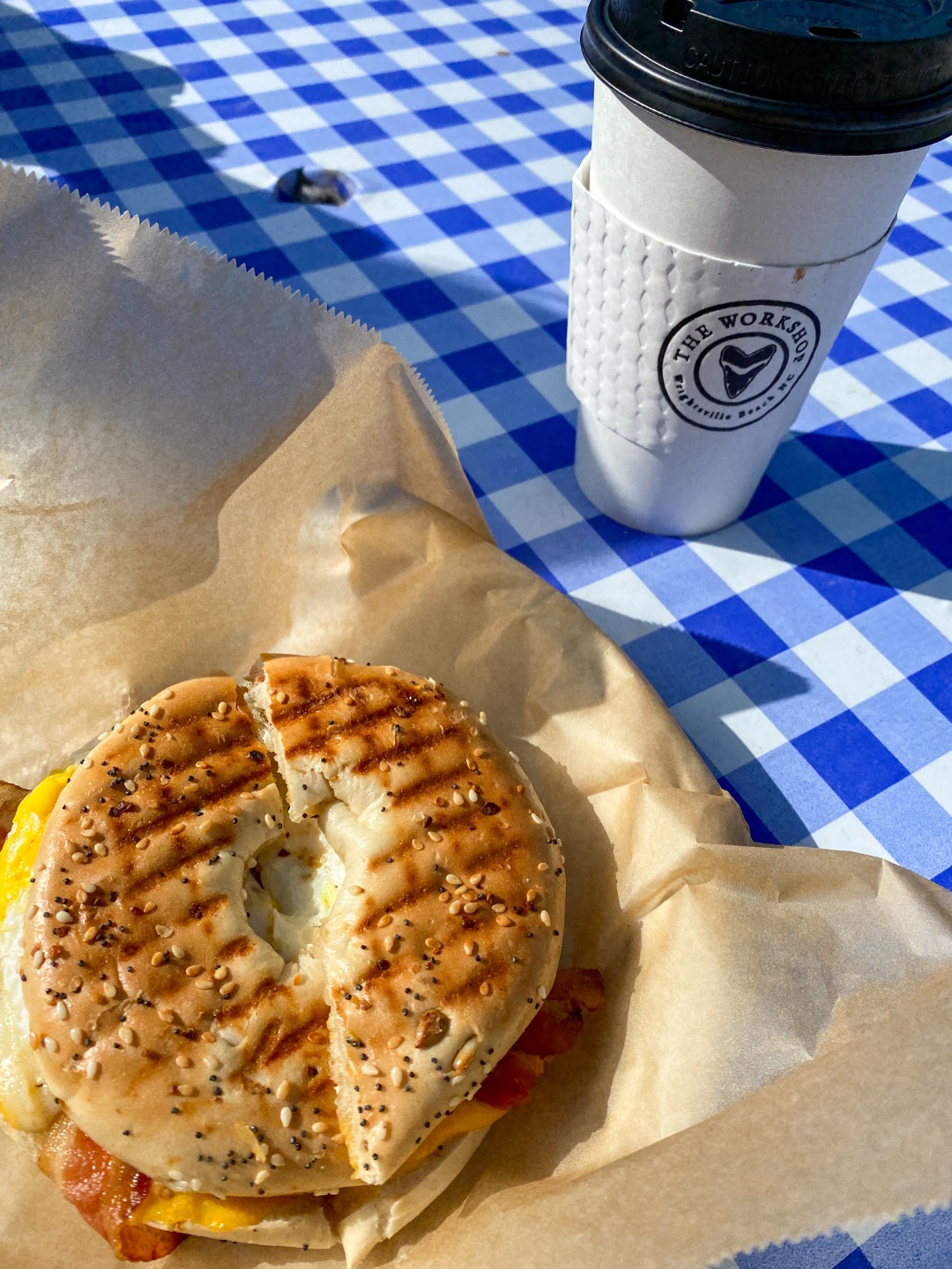 A Spring Weekend in Wilmington, NC: the Best Things to Do - I'm Fixin' To - @imfixintoblog |Weekend in Wilmington by popular NC travel blog, I'm Fixin' To: image of a bagel sandwich next to a The Workshop coffee cup. 