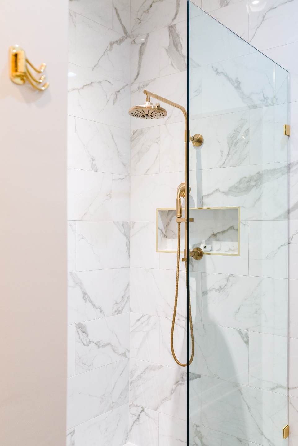 Places to Stay: The Colonial Inn in Hillsborough NC - I'm Fixin' To - @imfixintoblog |The Colonial Inn Hillsborough NC by popular NC travel blog, I'm Fixin' To: image of a walk-in shower with marble tiles and gold shower head.