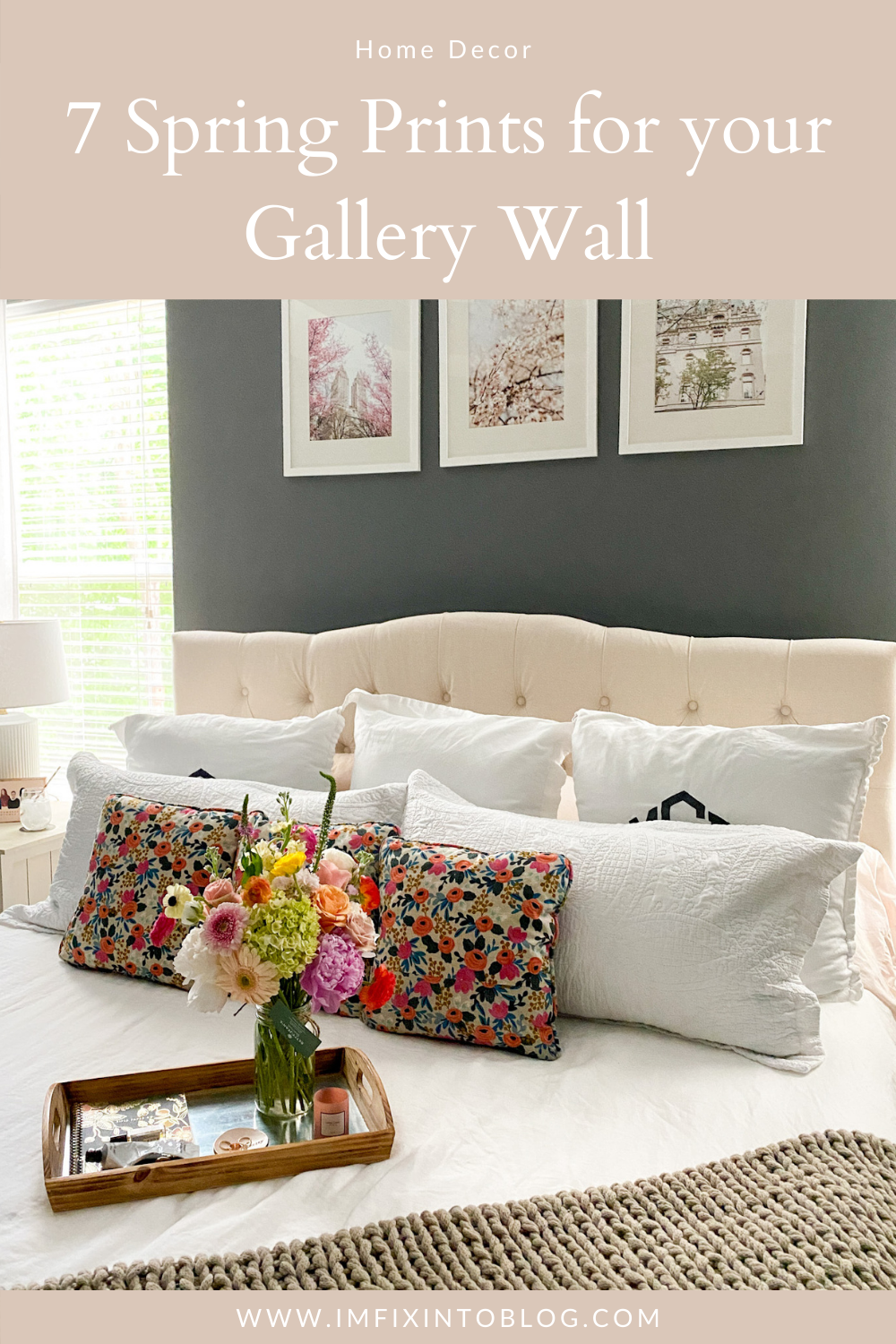 Home Decor: 7 Spring Prints for your Gallery Wall - I'm Fixin' To - @imfixintoblog | Spring Prints by popular NC life and style blog, I'm Fixin' To: Pinterest image of a dog sitting on a bed with a cream tuft head board, white bedding, floral print throw pillows and spring prints in white frames hanging above it on a grey accent wall.