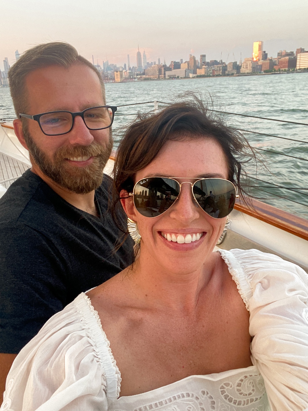 NYC Summer Weekend: Things to Do in NYC in the Summer - I'm Fixin' To - @imfixintoblog | NYC Summer Weekend by popular NC travel blog, I'm Fixin' To: image of a man and woman taking a selfie together on a boat with the NYC skyline behind them. 