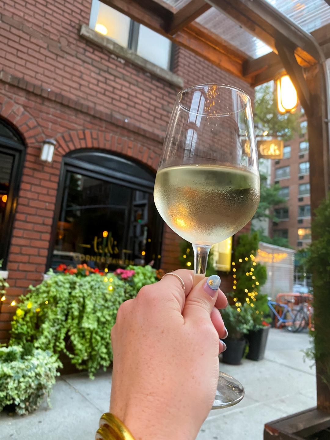 NYC Summer Weekend: Things to Do in NYC in the Summer - I'm Fixin' To - @imfixintoblog | NYC Summer Weekend by popular NC travel blog, I'm Fixin' To: image of a woman holding a glass of white wine at Ted's corner tavern. 