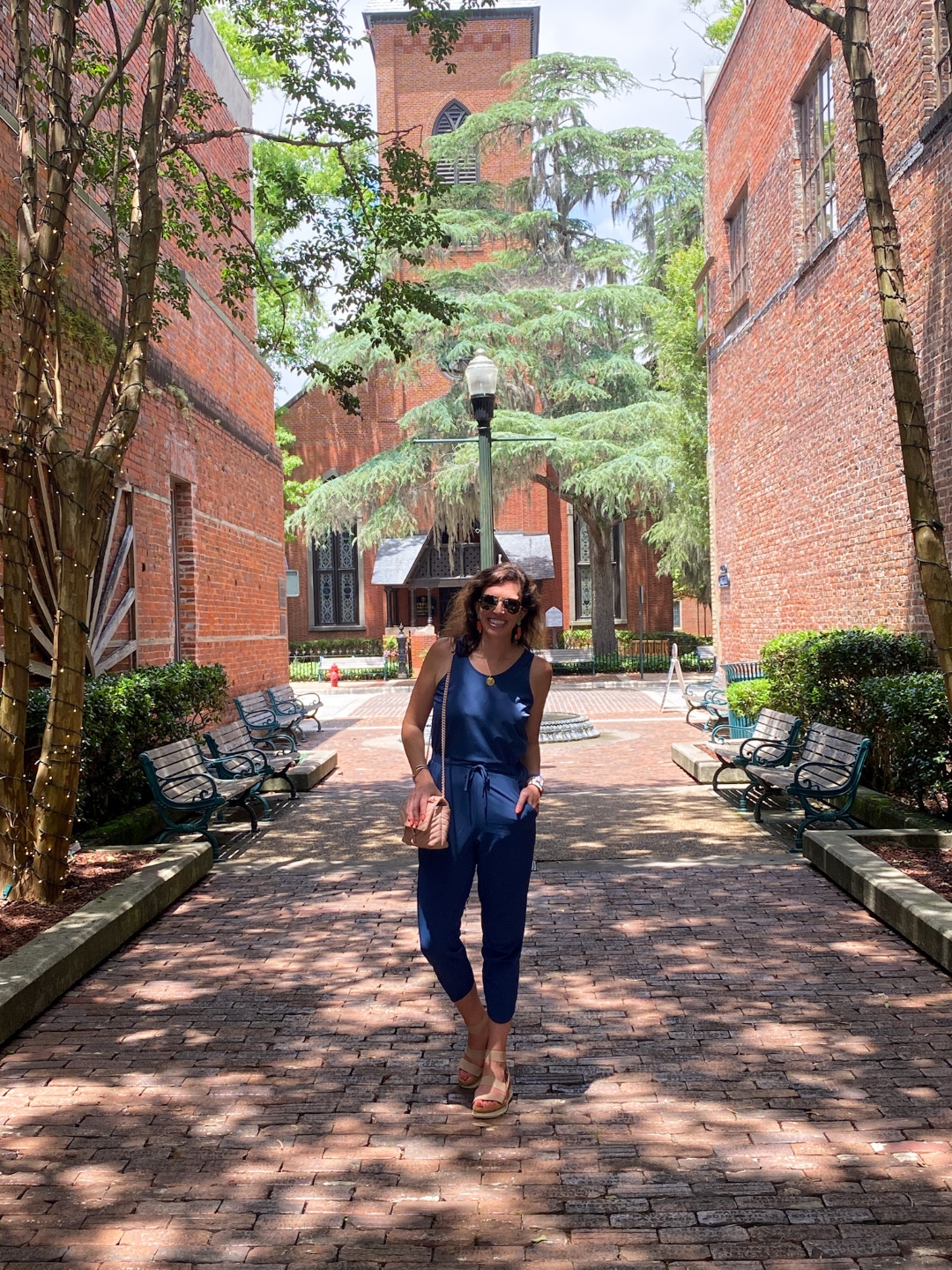 An Update on My North Carolina 100 County Tour - I'm Fixin' To - @imfixintoblog | Things to do in North Carolina by popular NC travel blog, I'm Fixin' To: image of a woman wearing a blue jumpsuit and standing on a brick paved road. 
