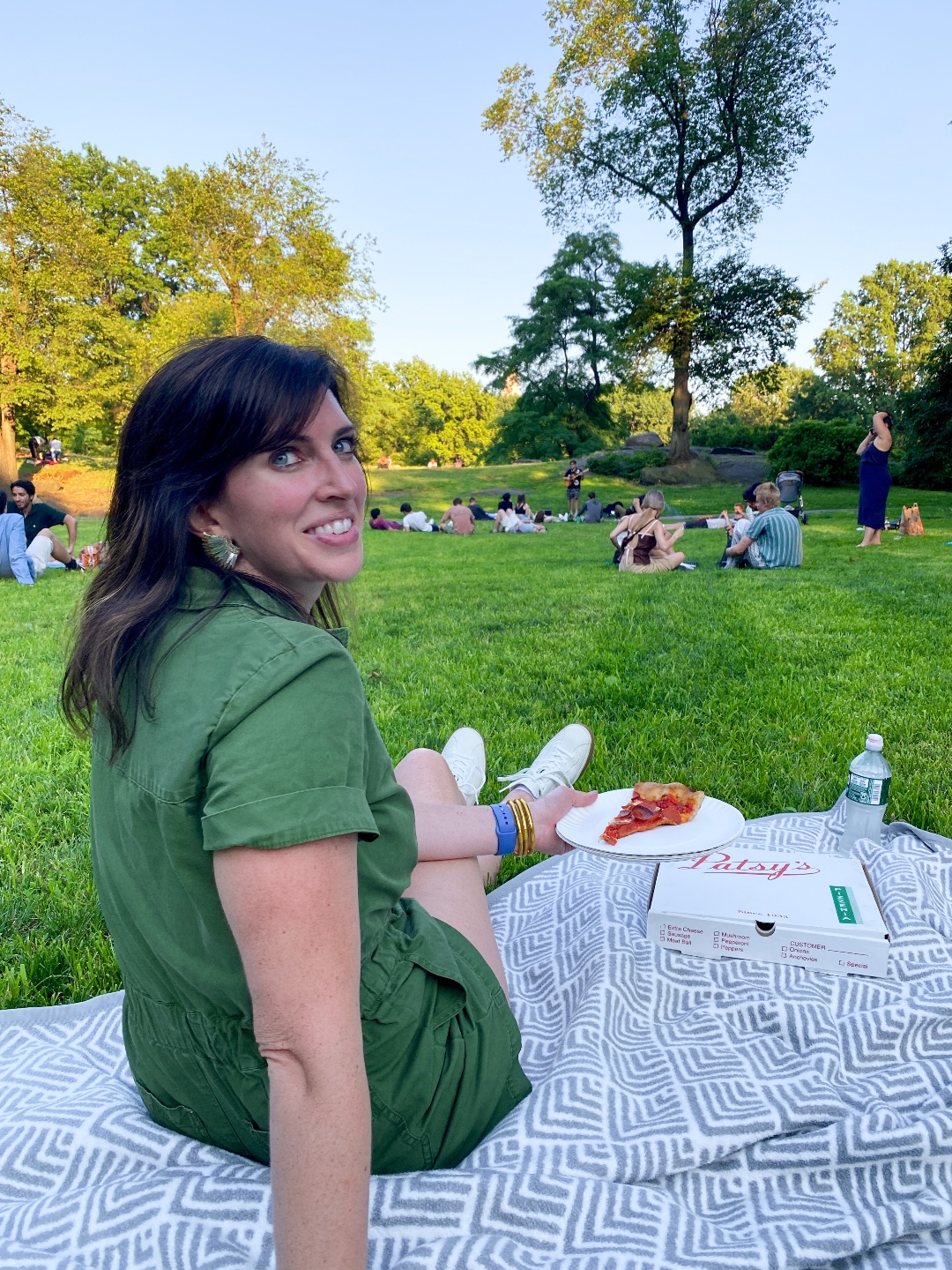 woman eating pizza at the park